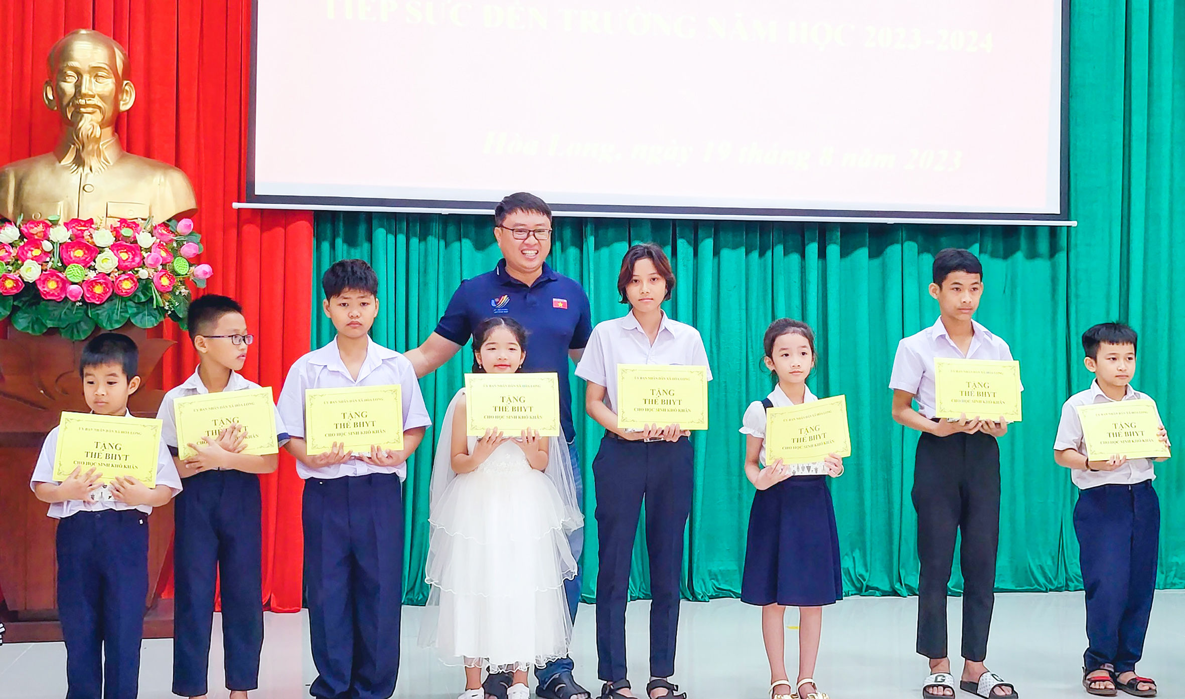 Đại diện Câu lạc bộ Phóng viên tỉnh Bà Rịa – Vũng Tàu trao tặng BHYT cho các em HS có hoàn cảnh khó khăn của xã Hòa Long.