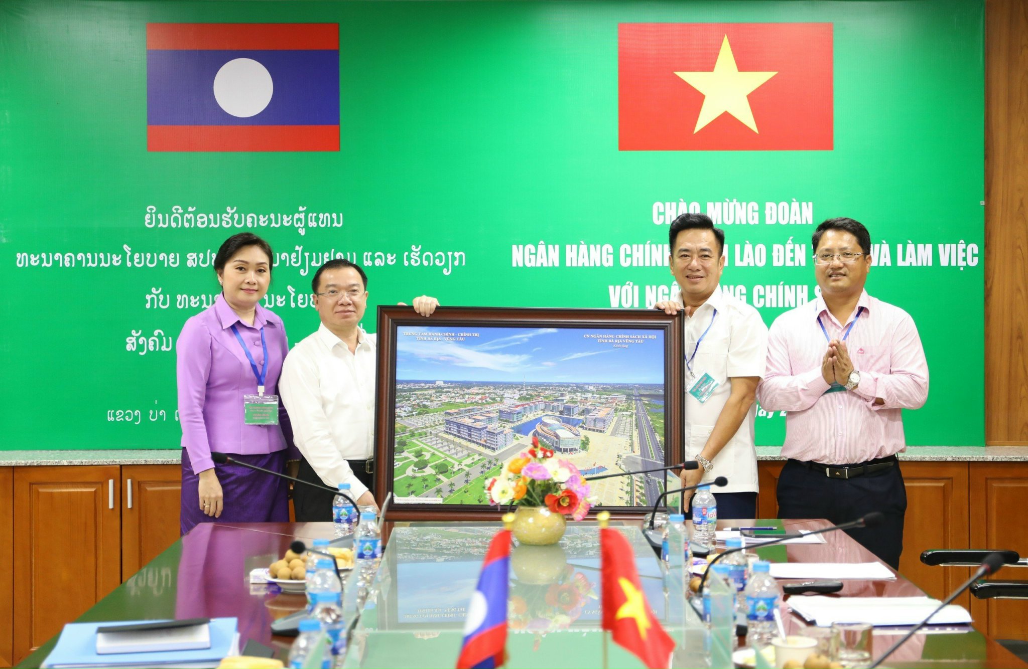 Ông Huỳnh Văn Thuận (bìa phải), Phó Tổng Giám đốc Ngân hàng CSXH Việt Nam tặng quà lưu niệm cho Đoàn Ngân hàng chính sách Lào.