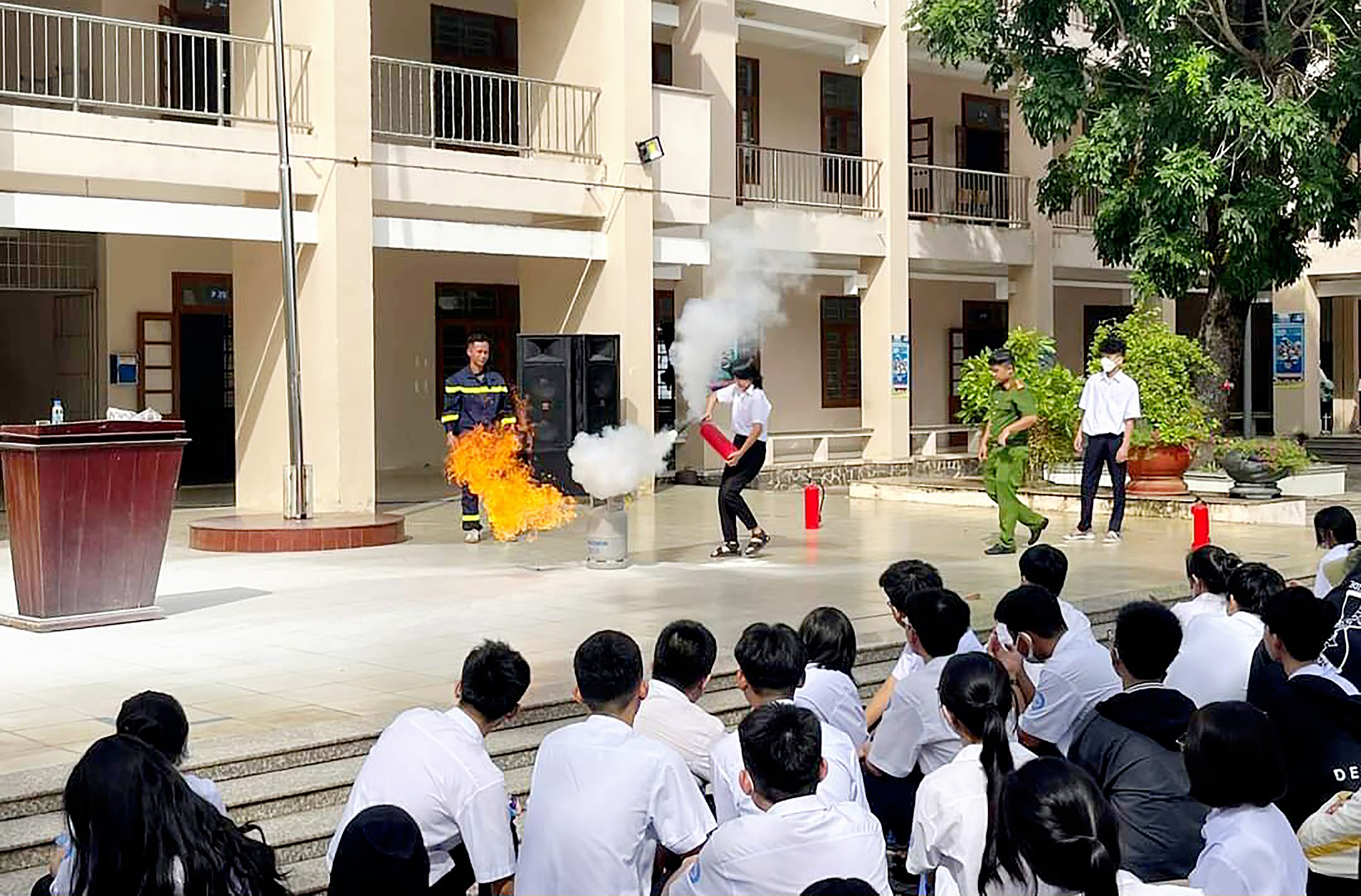 Công an huyện Xuyên Mộc hướng dẫn HS sử dụng bình PCCC cầm tay.