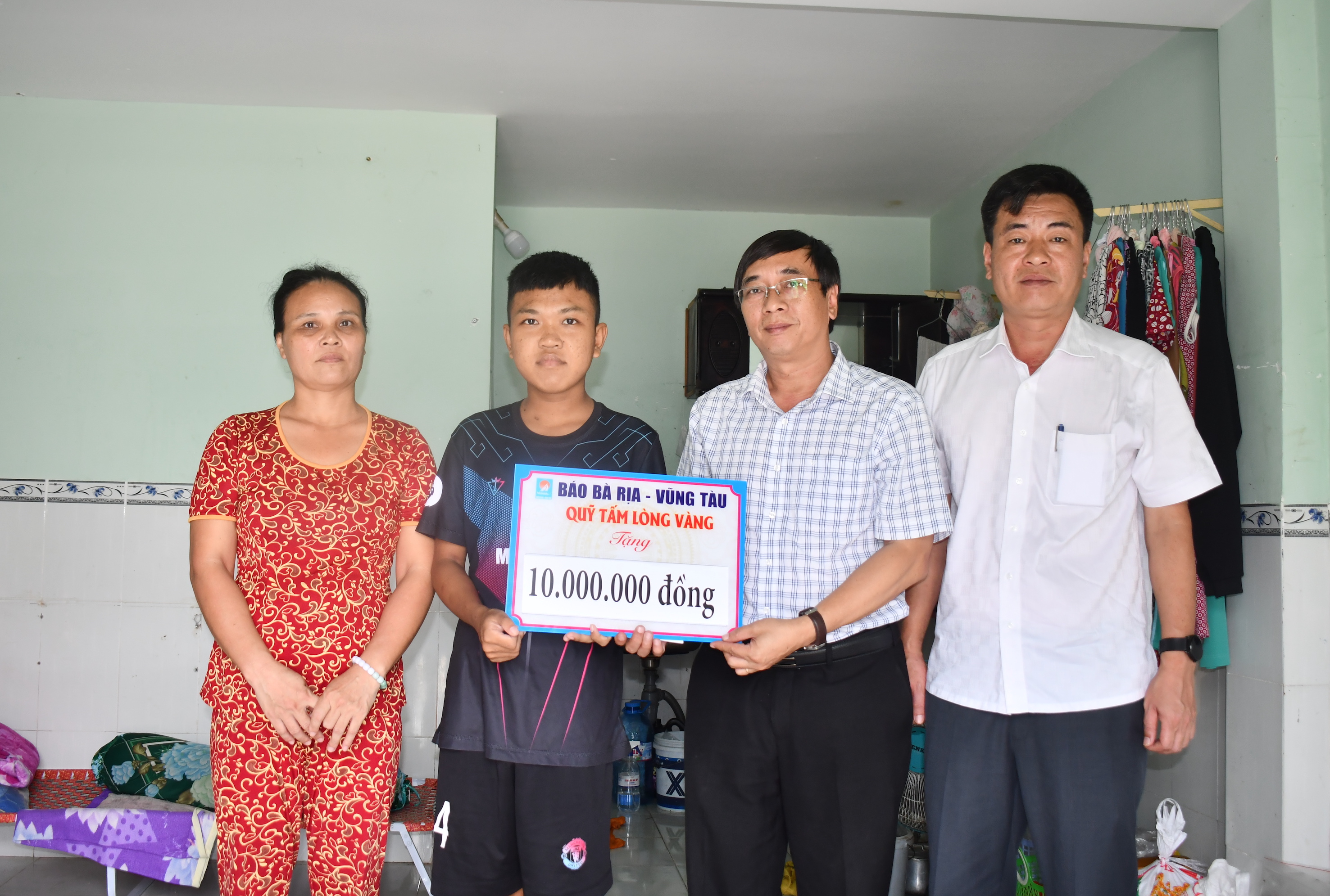 Ông Trương Đức Nghĩa, Phó Tổng Biên tập Báo Bà Rịa - Vũng Tàu trao số tiền 10 triệu đồng đến em Lâm Pháp.