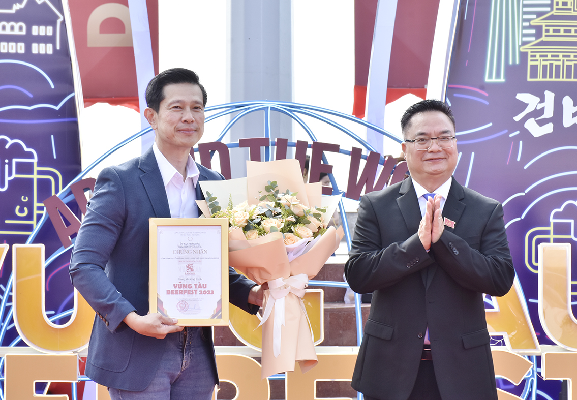 Ông Hoàng Vũ Thảnh, Chủ tịch UBND TP.Vũng Tàu (bên phải) tặng hoa và thư cảm ơn đại diện đơn vị tài trợ - ông Neo Gim Siong Bennet, Tổng Giám đốc Công ty CP Bia - Rượu - Nước giải khát Sài Gòn