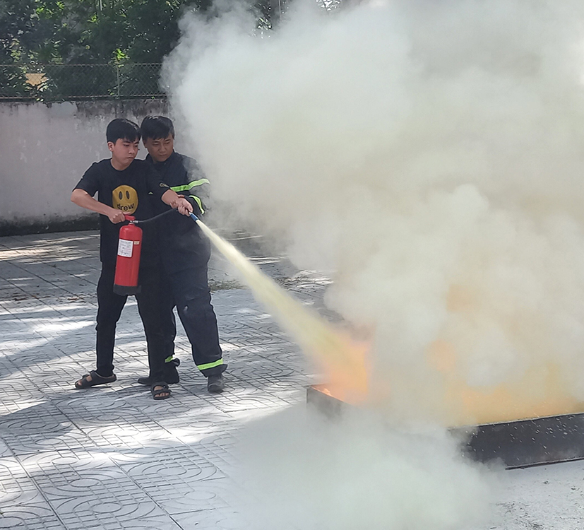 Cán bộ Đội Cảnh sát PCCC và CNCH, Công an TP.Vũng Tàu hướng dẫn người dân có nhà ở kết hợp kinh doanh sử dụng bình cứu hoả tại chỗ.