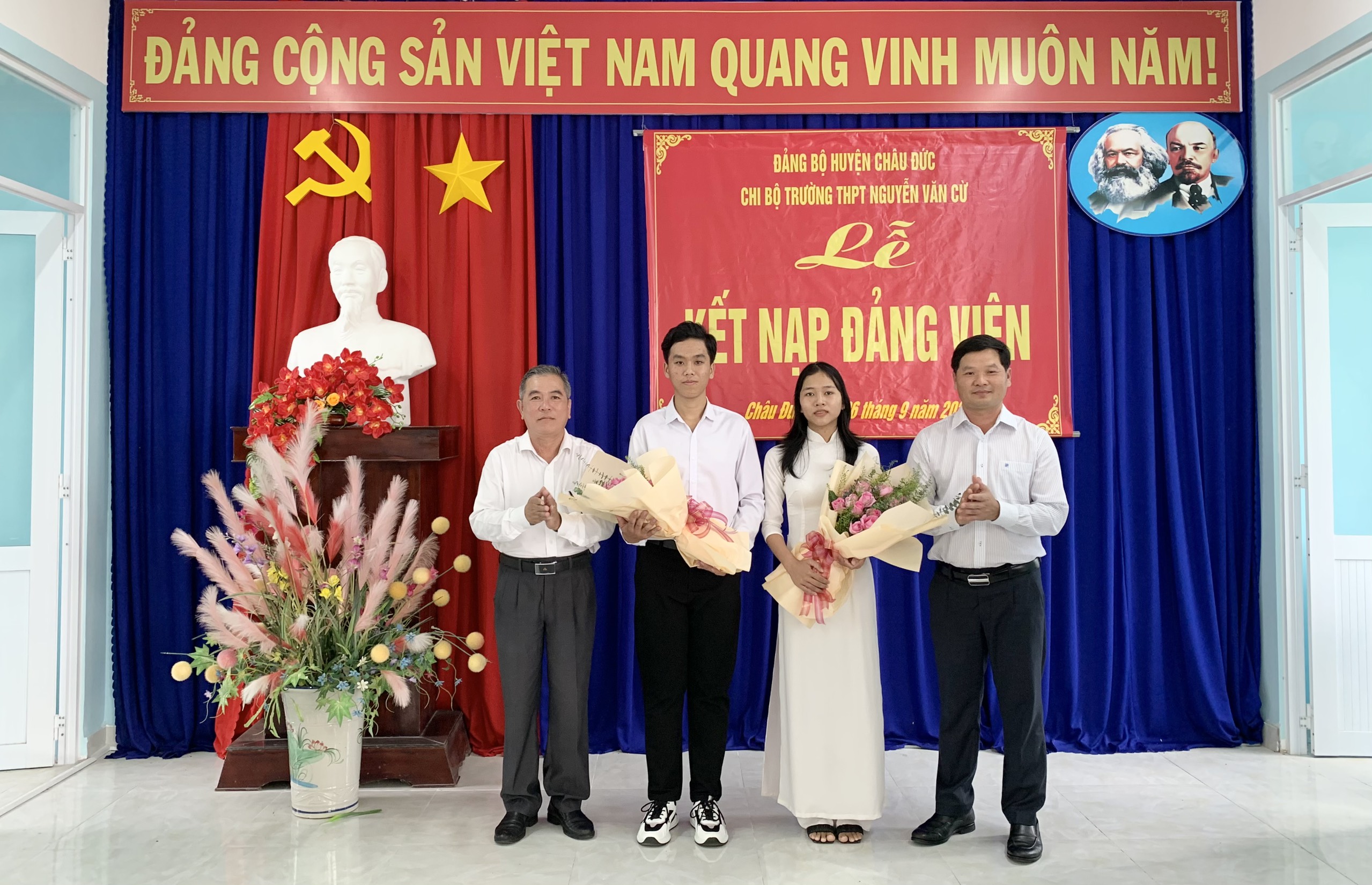 Ông Lê Thanh Liêm, Phó Bí thư Thường trực Huyện ủy Châu Đức và ông Bùi Văn Mỹ, Trưởng Ban Tổ chức Huyện ủy tặng hoa chúc mừng 2 HS ưu tú vừa được kết nạp vào đảng