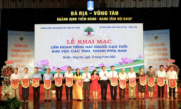 ông Nguyễn Thanh Bình, nguyên Ủy viên Trung ương Đảng, Chủ tịch Trung ương Hội NCT Việt Nam và ông Đặng Minh Thông, Phó Chủ tịch UBND tỉnh Bà Rịa - Vũng Tàu tặng cờ lưu niệm đến 14  Đoàn văn nghệ Người cao tuổi.