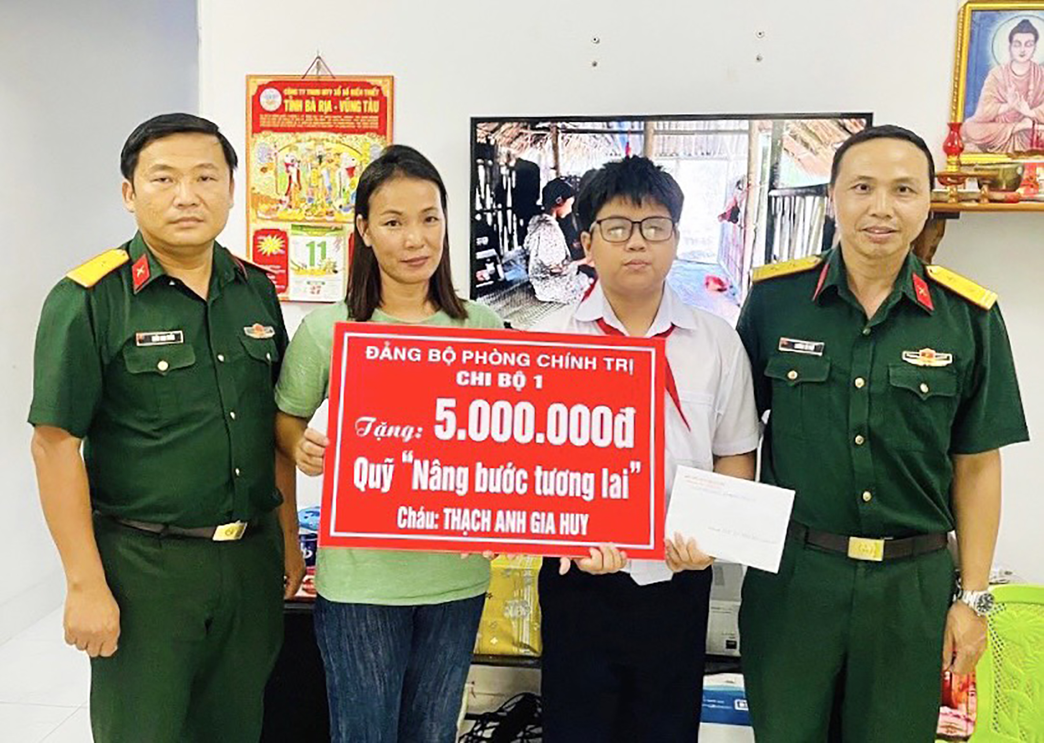 Đại diện Chi bộ 1, Đảng bộ Phòng Chính trị Bộ CHQS tỉnh trao bảng tượng trưng nhận đỡ đầu đến hết lớp 12 cho em Thạch Anh Gia Huy.