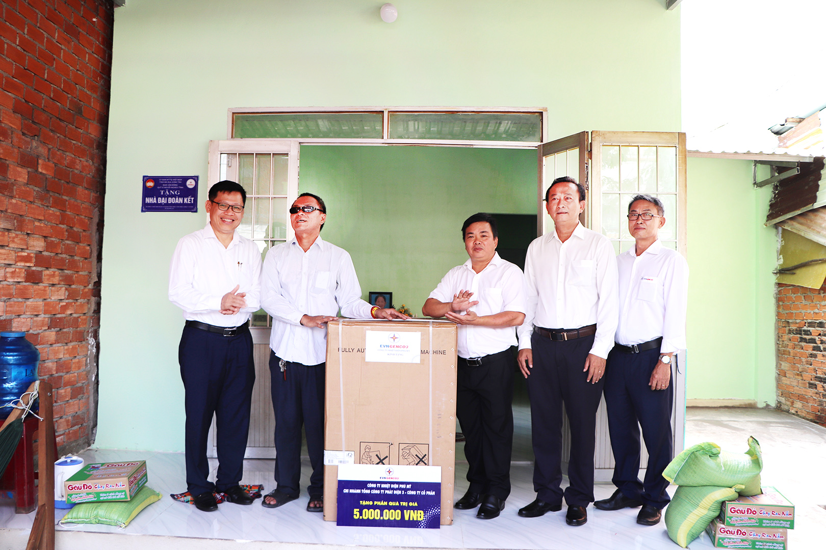 Không chỉ được hỗ trợ tiền xây dựng căn nhà mới, ông Đỗ Thế Vinh, xã Tân Hòa (thứ 2 từ trái qua) còn được đơn vị tài trợ tặng chiếc máy giặt để tiện sinh hoạt.
