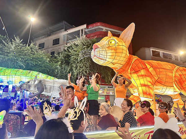 Người dân tham gia diễu hành trên những chiếc xe mô hình lồng đèn Trung thu.