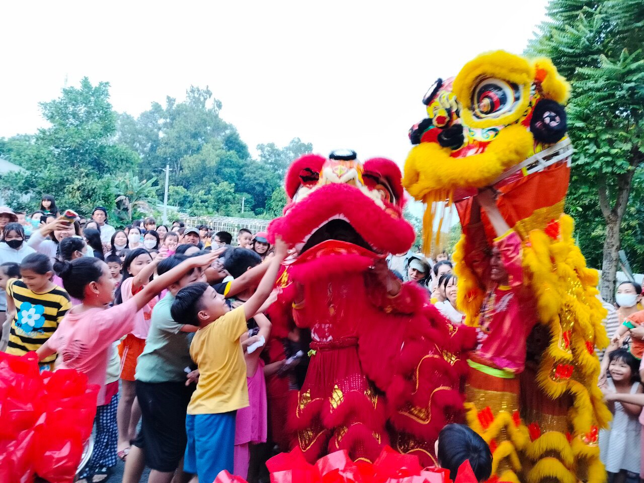 Các em nhỏ thích thú khi được chạm vào con lân tại chương trình  Trung thu cho em, tổ chức tại khuôn viên Trung tâm LDT (xã Châu Pha).