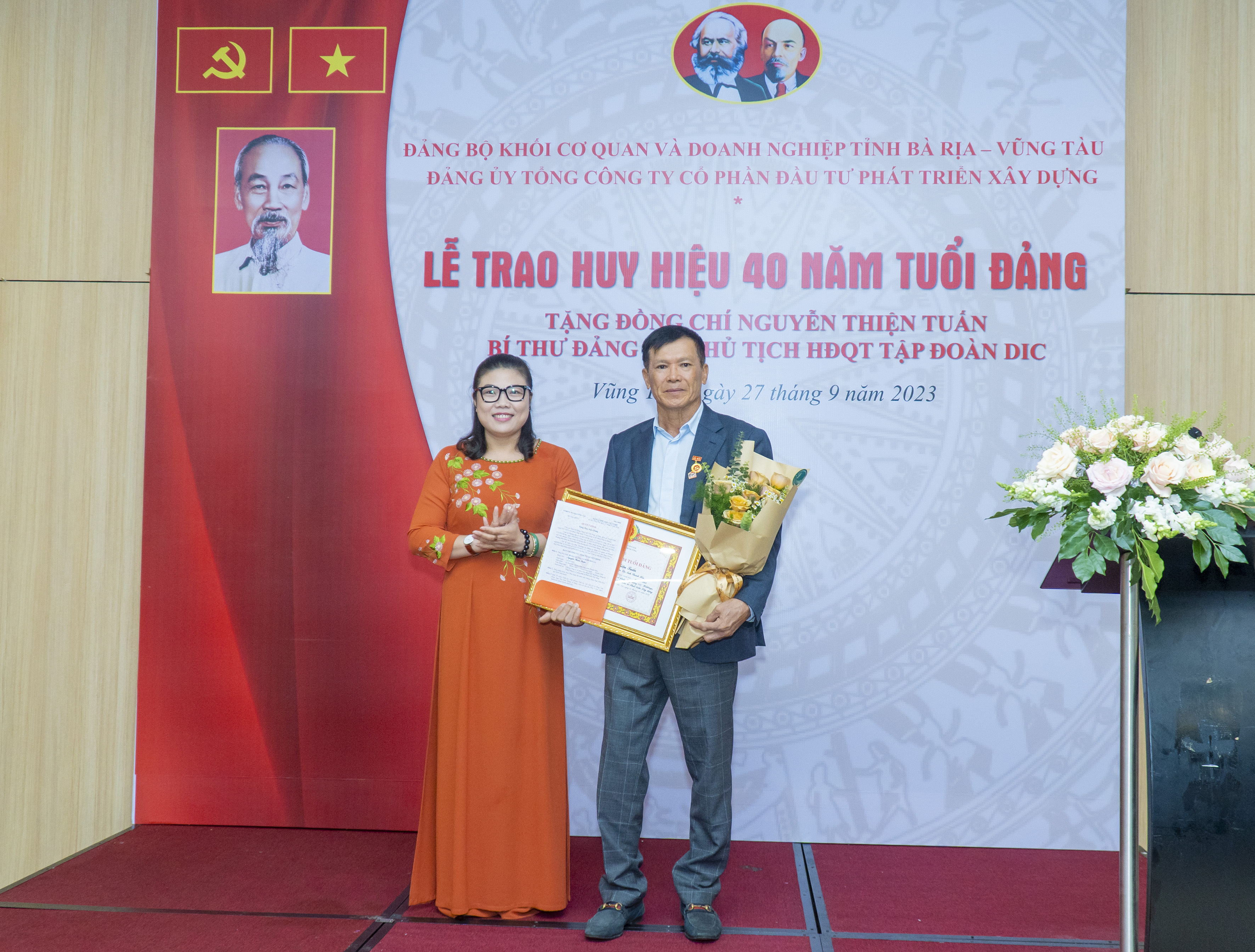 Bà Lương Thị Lệ Hằng, Bí thư Đảng ủy Khối Cơ quan và Doanh nghiệp tỉnh trao Quyết định và tặng hoa chúc mừng đảng viên Nguyễn Thiện Tuấn.