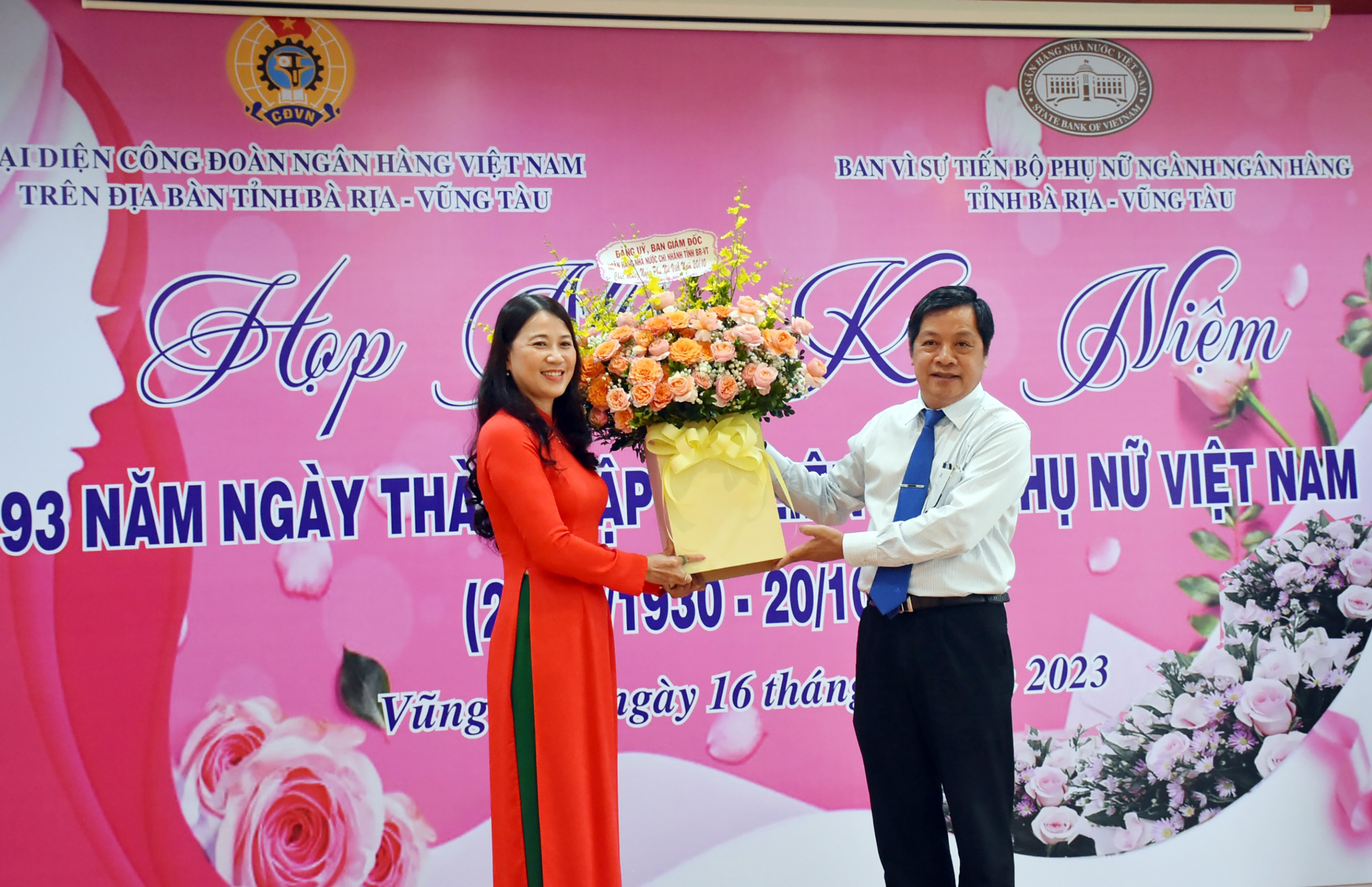 Ông Nguyễn Lợi, Giám đốc NHNN chi nhánh Bà Rịa-Vũng Tàu, Trưởng ban vì sự tiến bộ ngành ngân hàng tỉnh tặng hoa cho bà Lâm Thị Hồng Ngọc, Chủ tịch Công đoàn ngành ngân hàng, Phó Giám đốc NHNN- chi nhánh tỉnh.