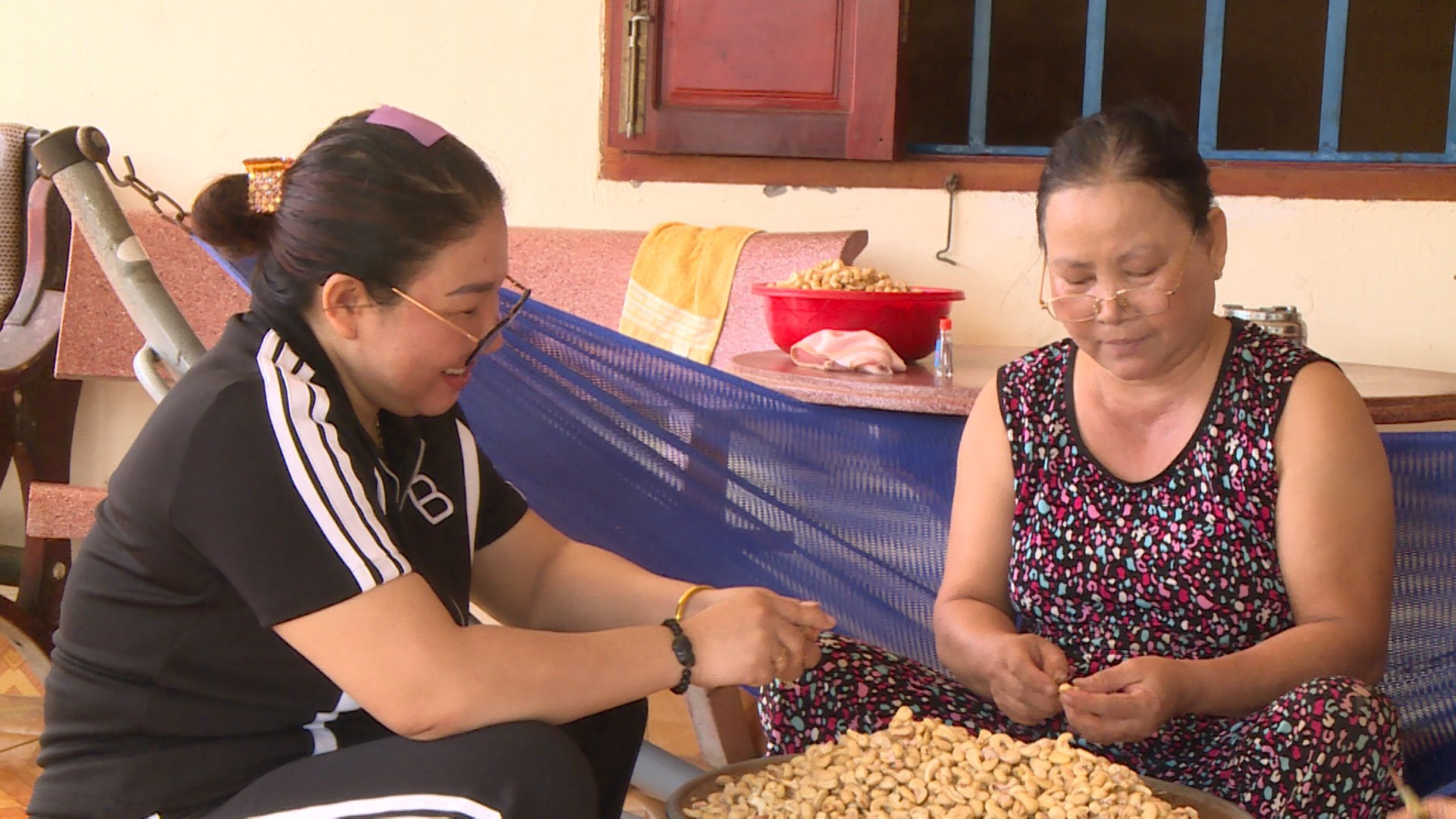 Chị Thuý Vân (trái) bóc hạt điều cùng lao động nữ.