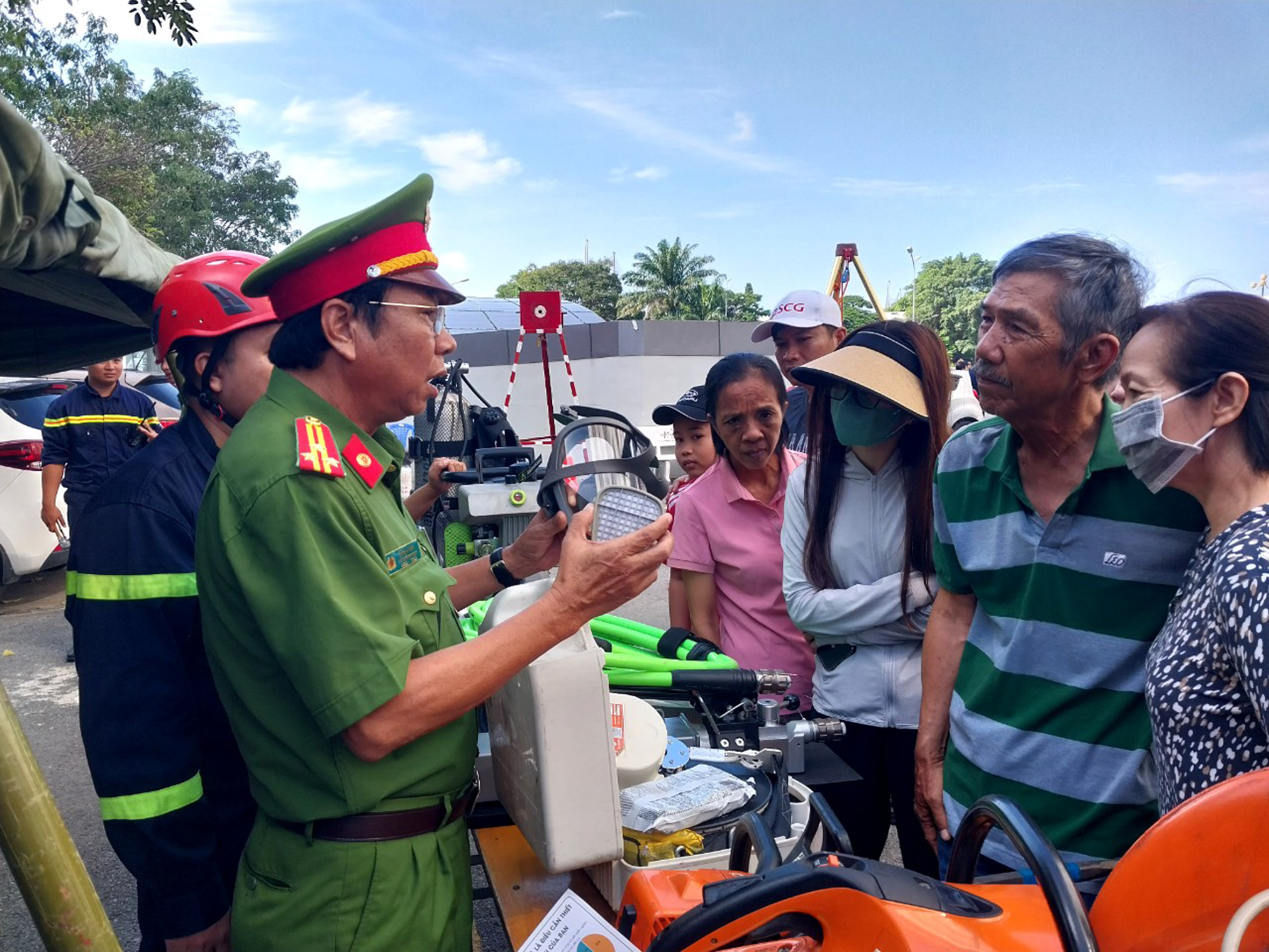 Cảnh sát PCCC (Công an tỉnh) hướng dẫn cách sử dụng mặt nạ chống độc cho người dân.