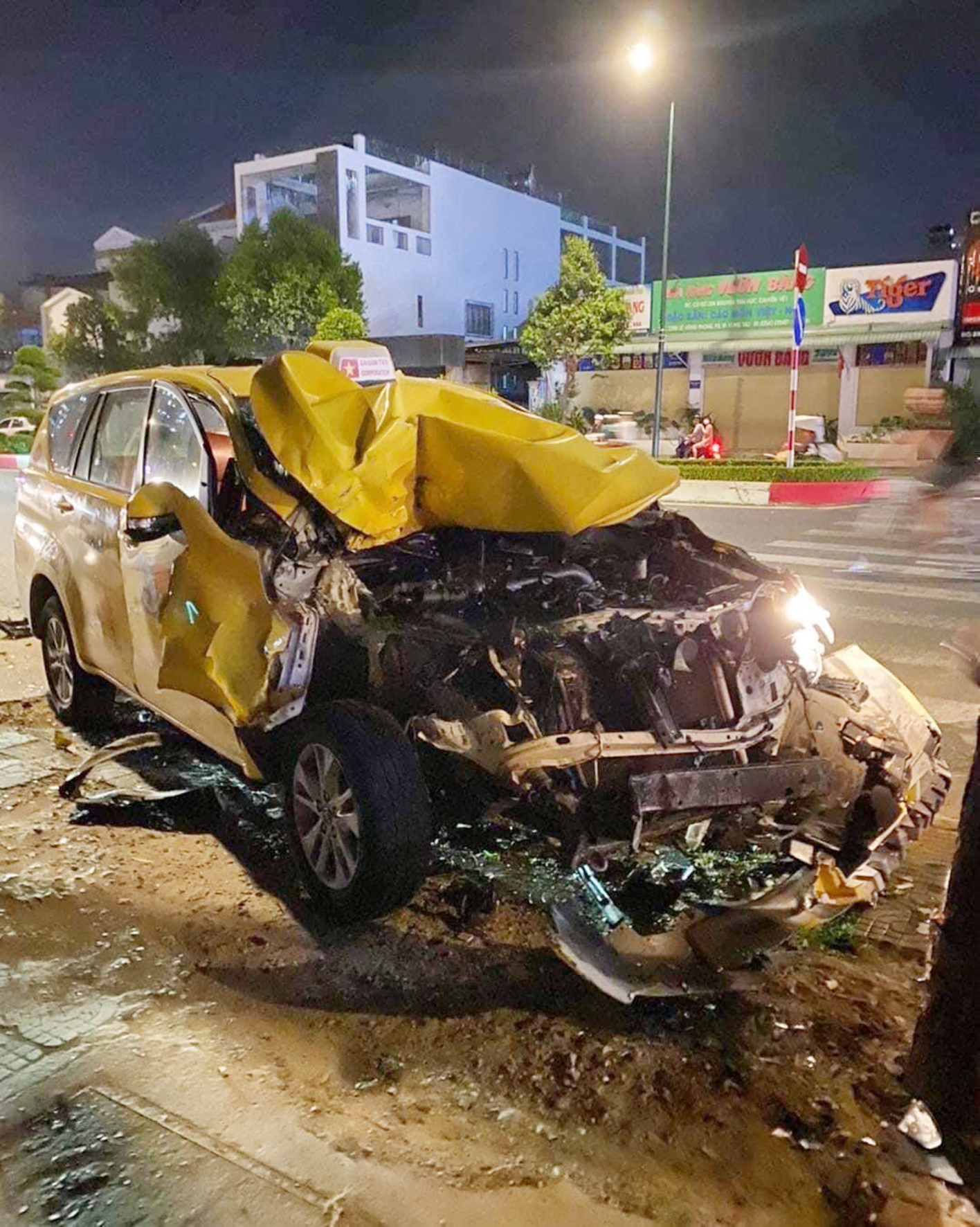 Xe taxi nát phần đầu sau khi tông vào đuôi xe tải rồi lao vào gốc cây trên vỉa hè. (Ảnh: Yêu Vũng Tàu)