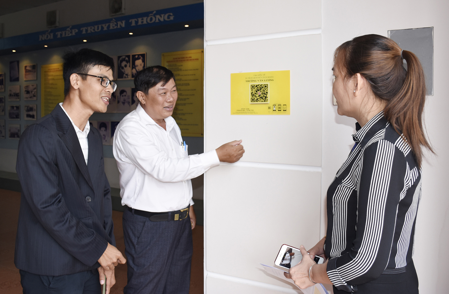 Ông Đỗ Phước Trung, Phó Giám đốc Sở Du lịch gắn mã QR code tại Trường THCS Văn Lương.