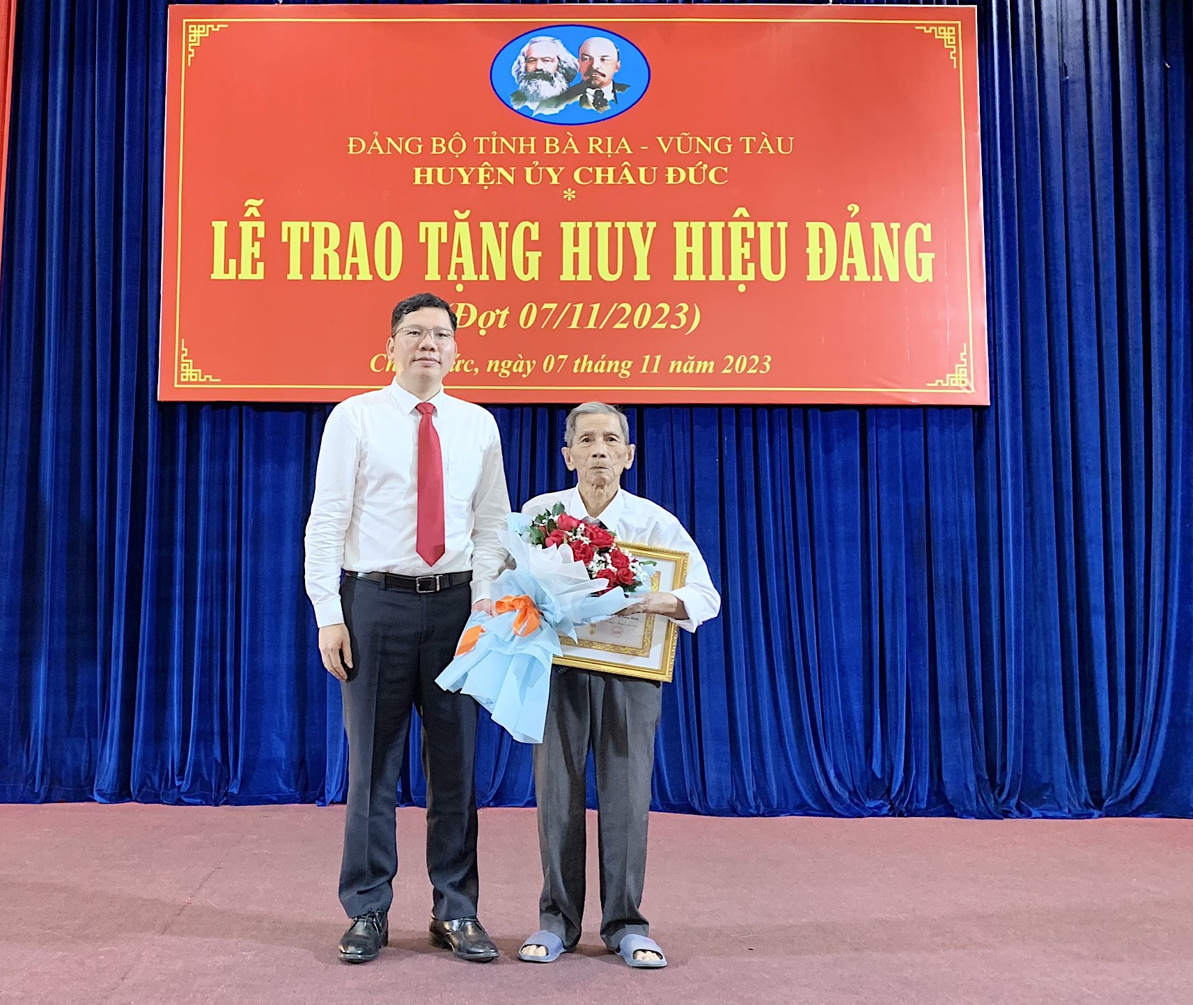 Ông Hoàng Nguyên Dinh, Tỉnh uỷ Viên, Bí thư Huyện uỷ huyện Châu Đức trao Huy hiệu đảng cho đảng viên Trần Văn Vui.