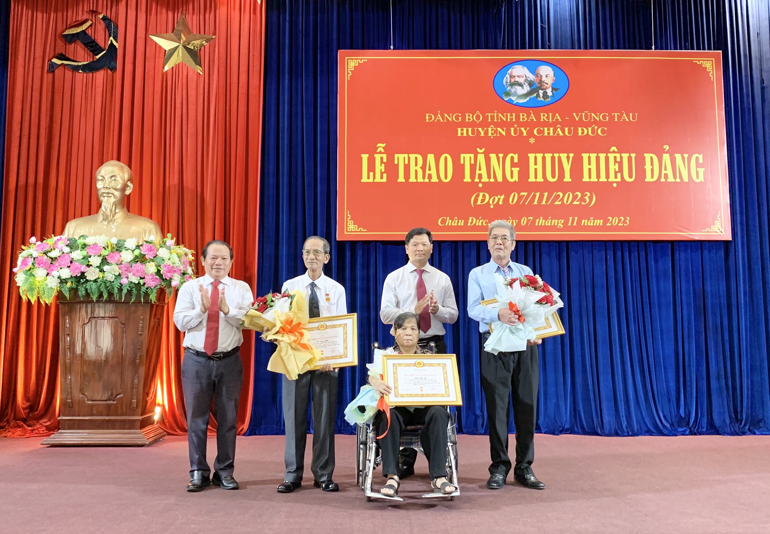 Ông Lê Thanh Liêm, Phó Bí thư Thường trực Huyện uỷ Châu Đức trao Huy hiệu Đảng và hoa chúc mừng các đảng viên.
