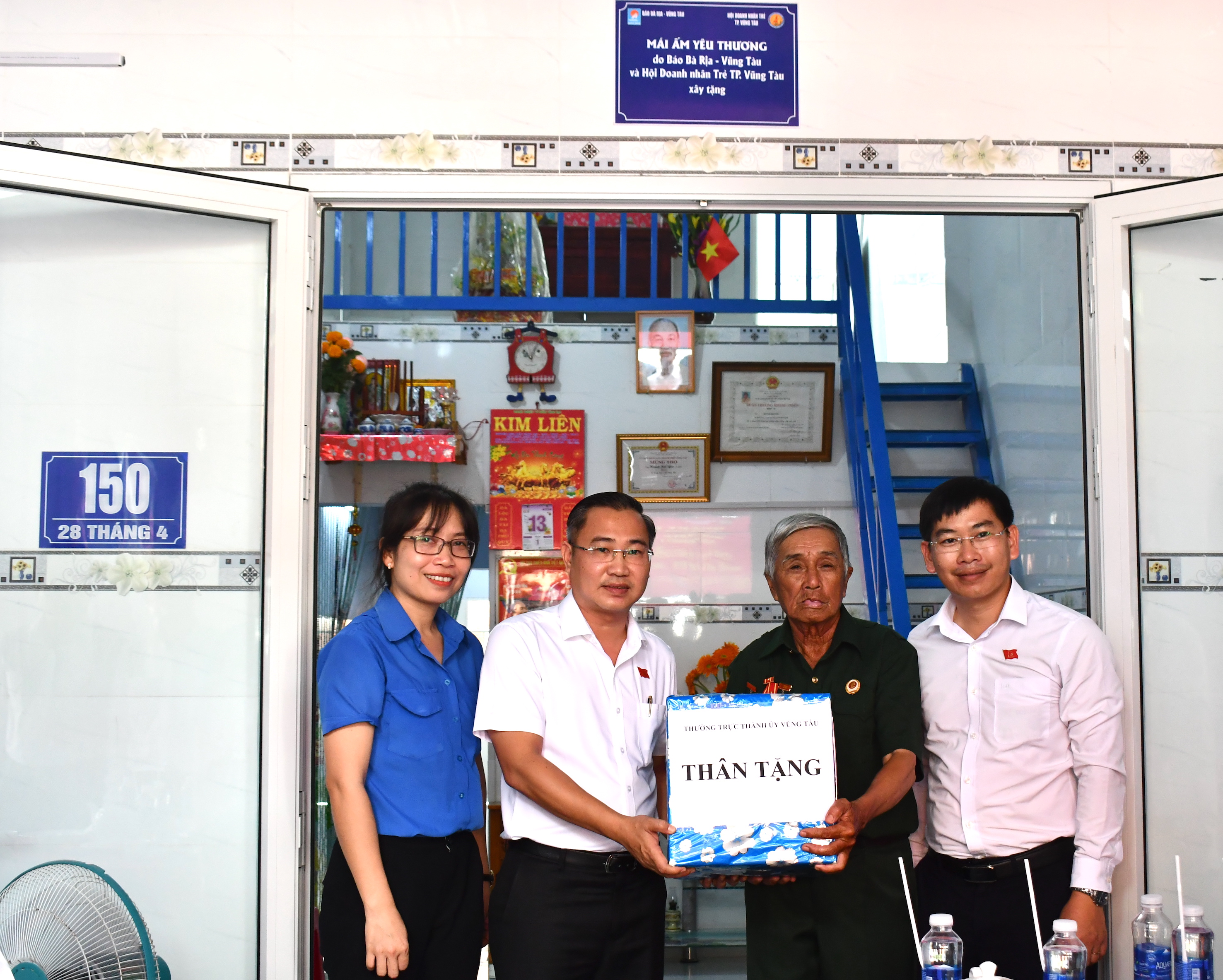 Ông Lê Xuân Tú, Trưởng Ban Dân vận Thành ủy Vũng Tàu, ông Hà Hữu Dũng, Bí thư Đảng ủy xã Long Sơn trao quà đến ông Huỳnh Hải Yên.