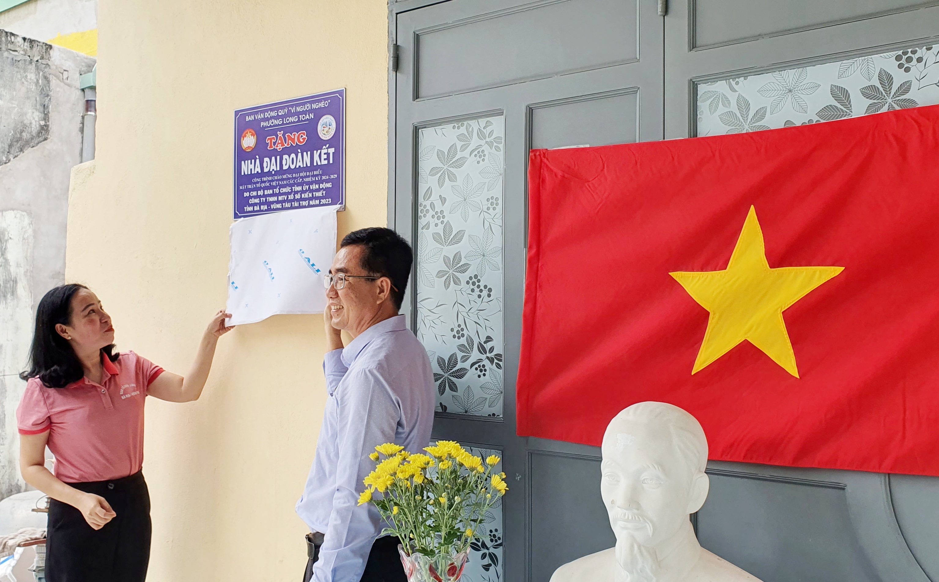 bà Võ Ngọc Thanh Trúc, Phó Trưởng Ban Tổ chức Tỉnh uỷ, Phó Bí thư Chi bộ Ban Tổ chức Tỉnh uỷ  và nhà tài trợ mở bảng trao nhà cho hộ bà Đoàn Thị Thái Thanh, tổ 9, KP1, phường Long Toàn 