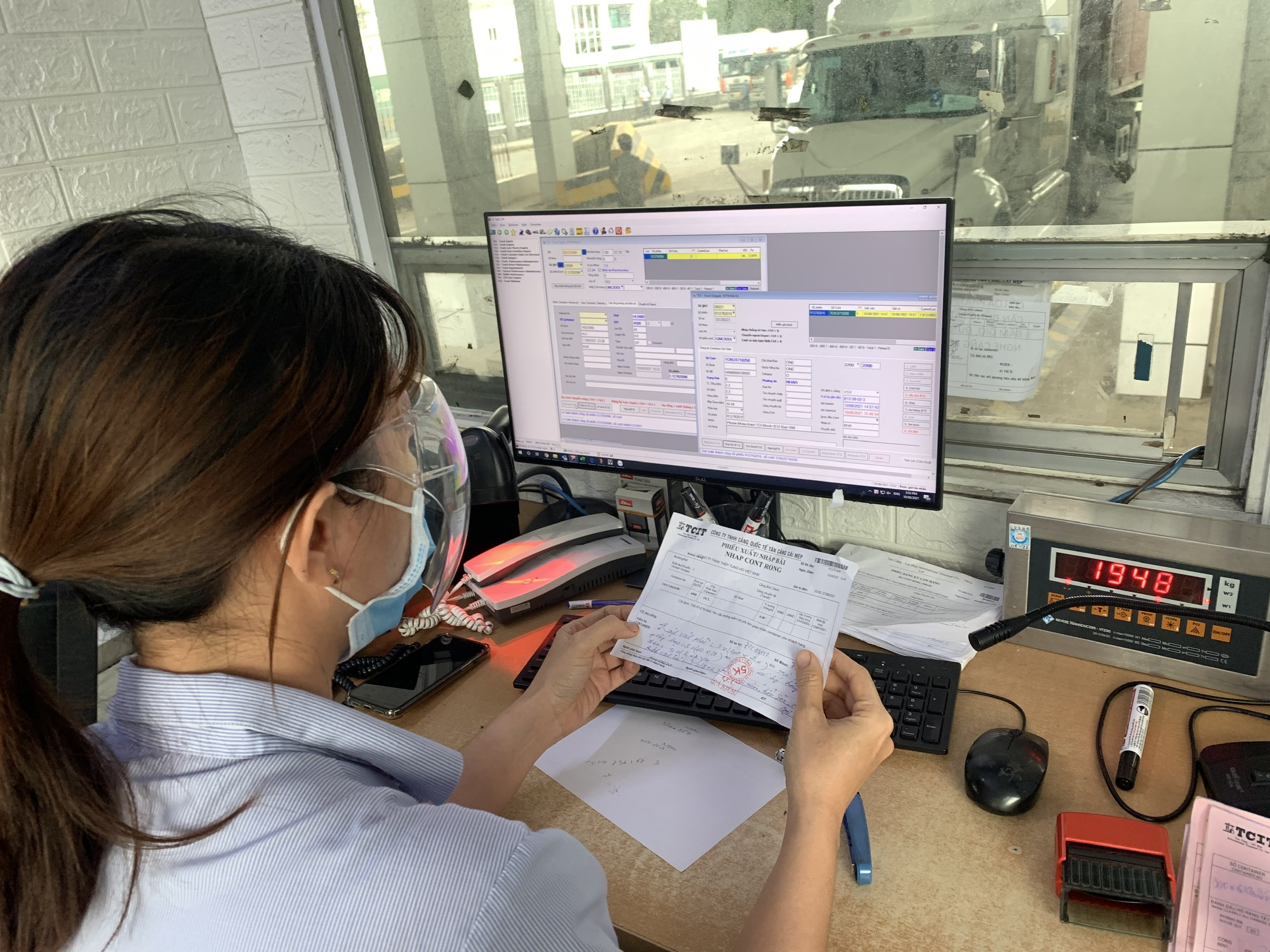 Nhân viên giám sát cổng cảng tại Cảng TCIT kiểm soát thông tin về tải trọng cho phép của xe trên phần mềm máy tính.