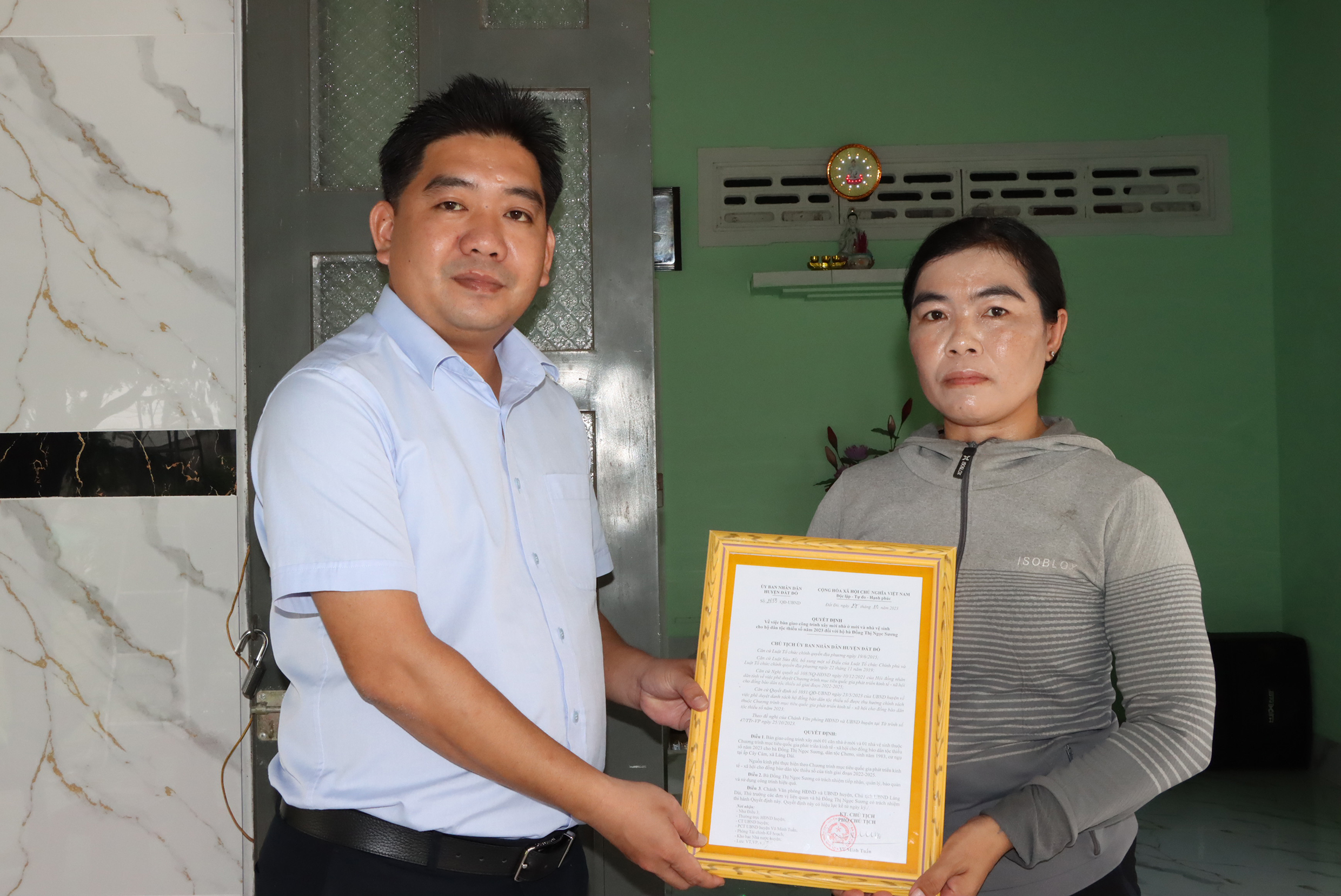 Ông Võ Minh Tuấn, Phó Chủ tịch UBND huyện trao Quyết định bàn giao nhà cho hộ bà Đoàn Thị Ngọc Sương, dân tộc Chơro, cư ngụ tại ấp Cây Cám, xã Láng Dài.