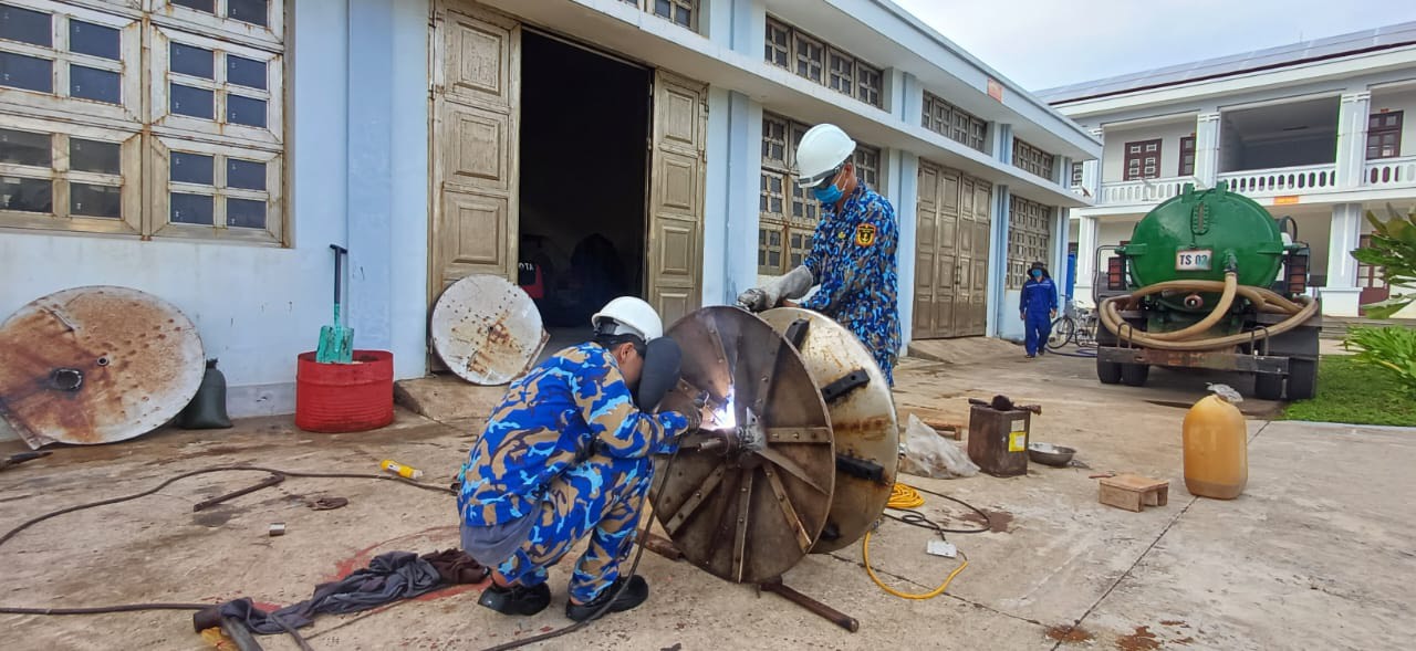 Nhân viên kỹ thuật Trung tâm Hậu cần - Kỹ thuật đảo Trường Sa khắc phục sự cố tời lưới cho tàu cá.