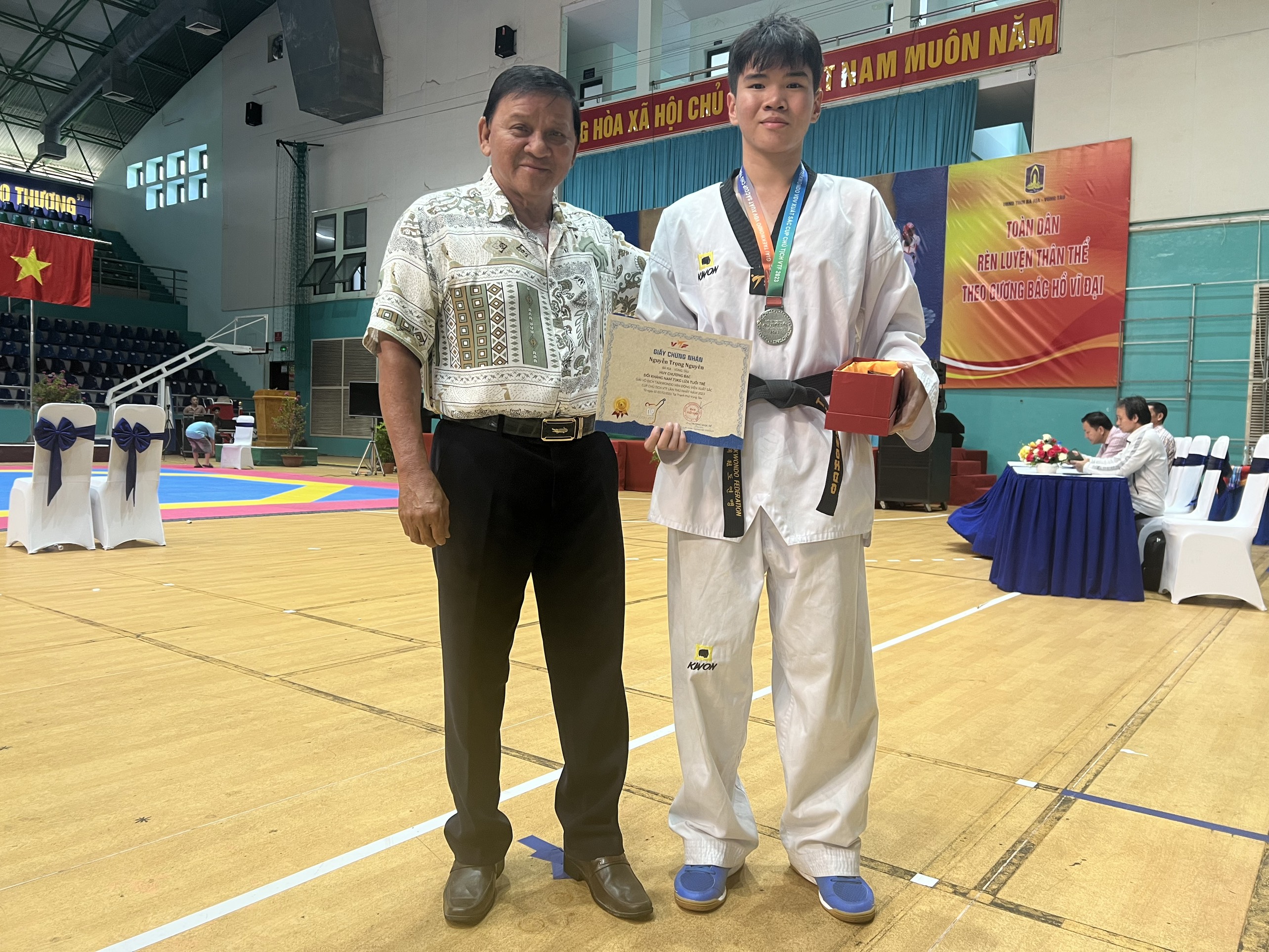 Ông Đặng Văn Cường, Giám đốc Trung tâm Huấn luyện và Thi đấu TDTT tỉnh chúc mừng thành tích giành HCB quốc gia của VĐV Trọng Nguyên.