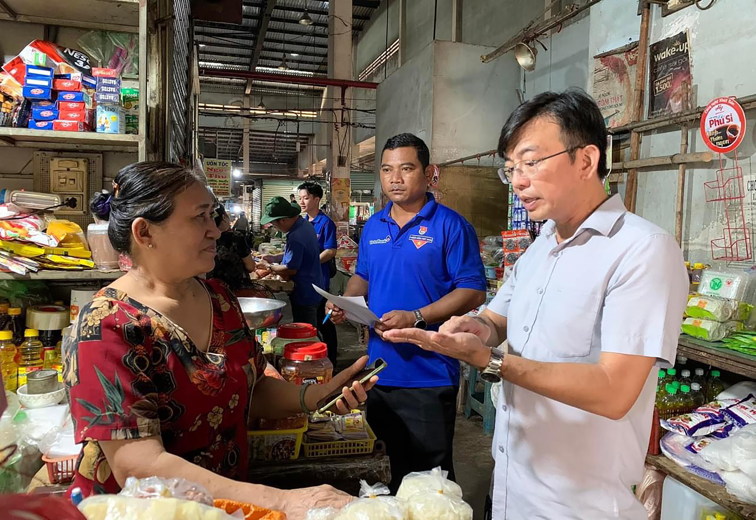 Lãnh đạo TT.Ngãi Giao cùng các đoàn viên thanh niên hướng dẫn tiểu thương chợ Ngãi Giao cài đặt và sử dụng các ứng dụng số.