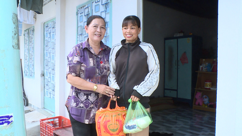 Bà Trần Thị Ngọc Lan (bên trái) tặng quà phụ nữ khó khăn tại phường Phước Hiệp.