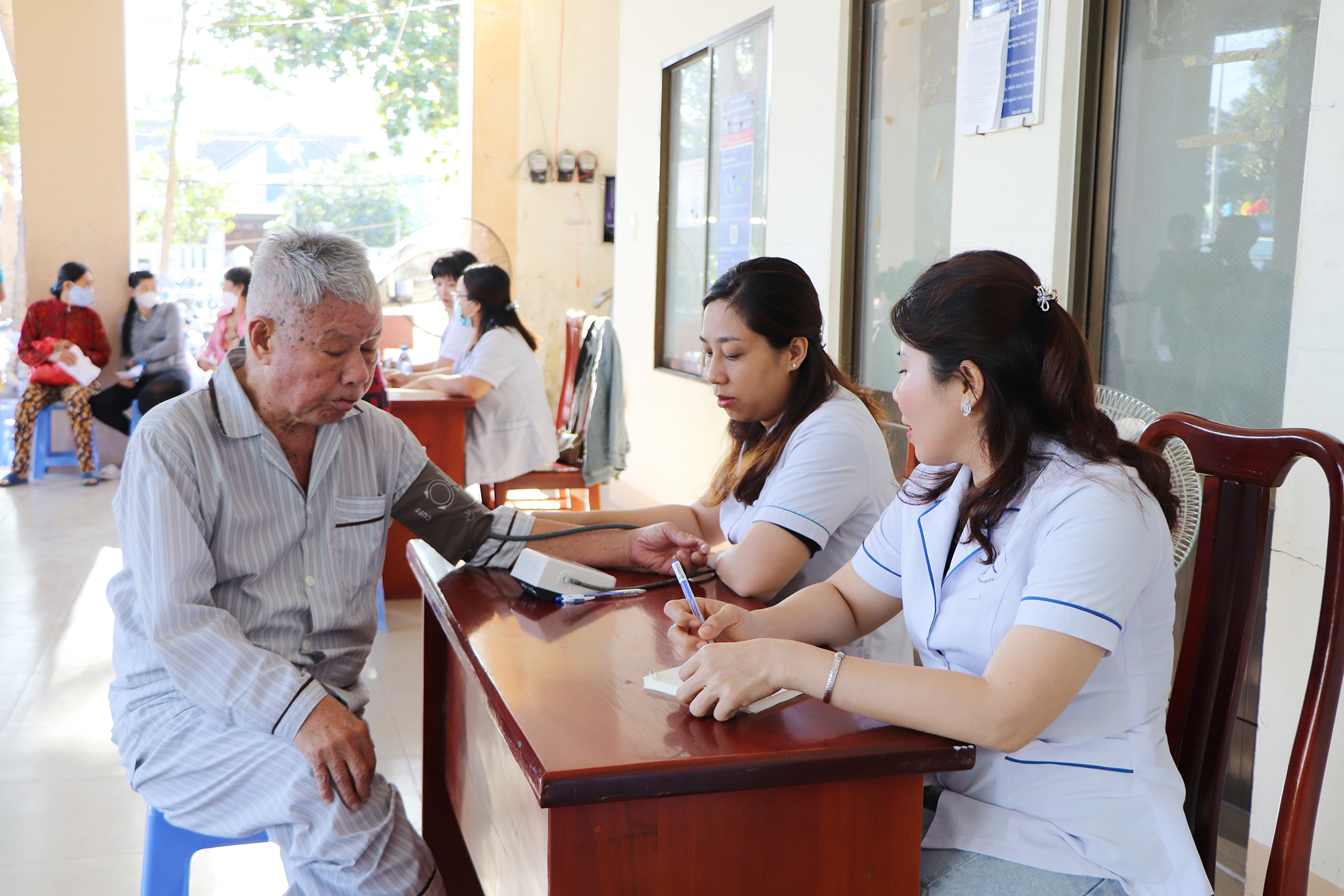 Người dân đến khám được kiểm tra huyết áp.