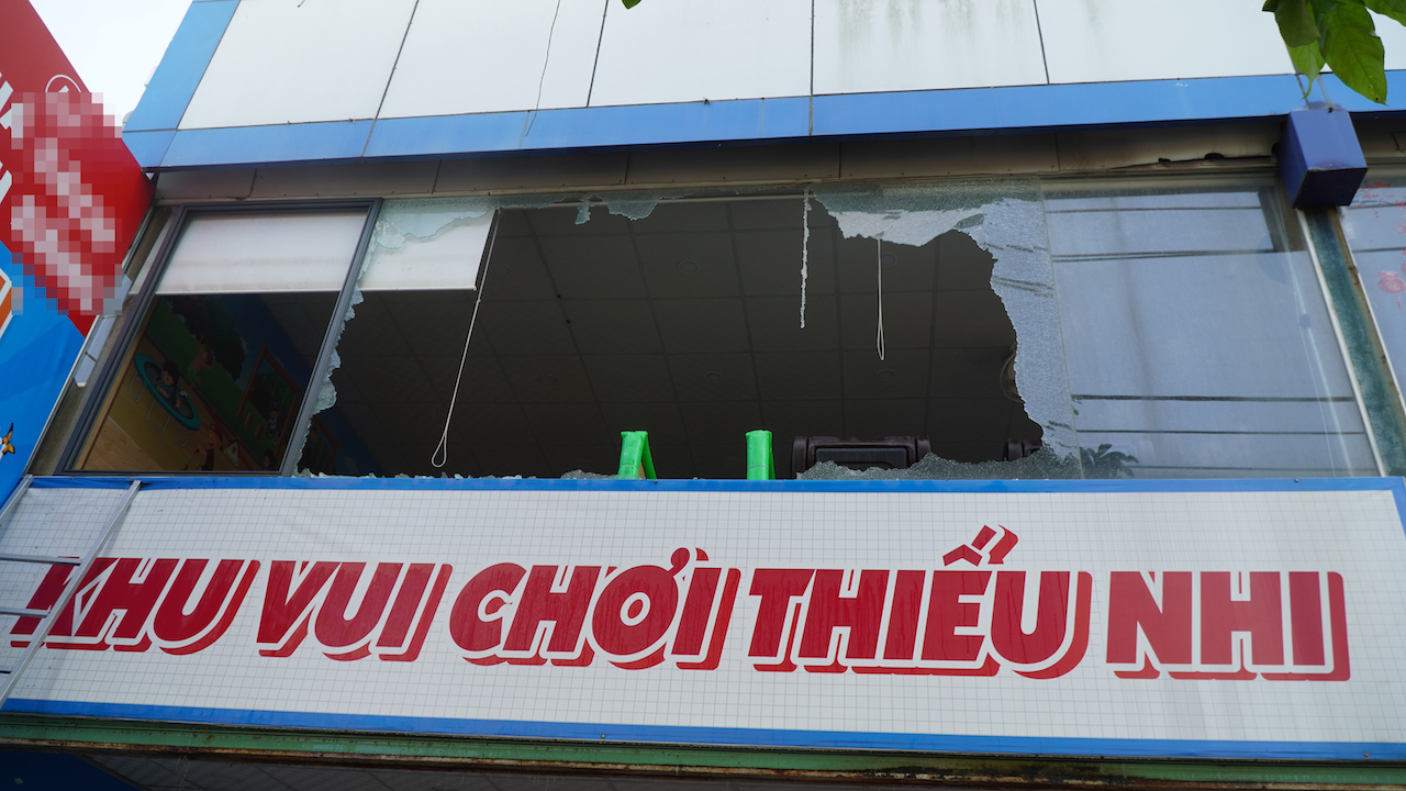 Lực lượng chức năng phá kính cường lực phía trước nhà sách để phun nước vào khống chế đám cháy.