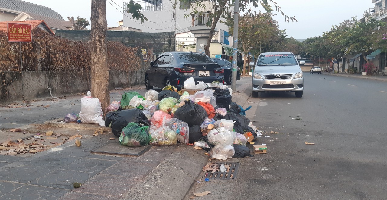 Rác chất đống trên vỉa hè và dưới lòng đường dù nơi đây có đặt biển cấm (ảnh chụp lúc 6 giờ 15 sáng 7/1).