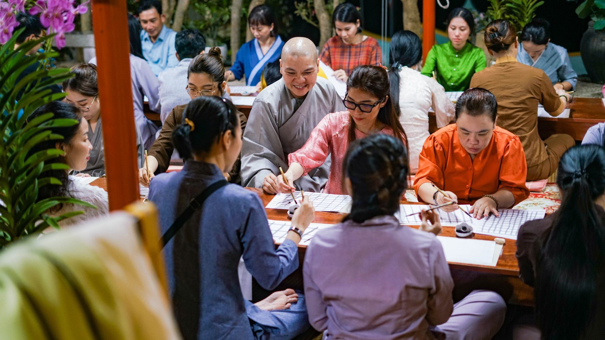 Sư cô Huệ Trí hướng dẫn học viên viết chữ thư pháp