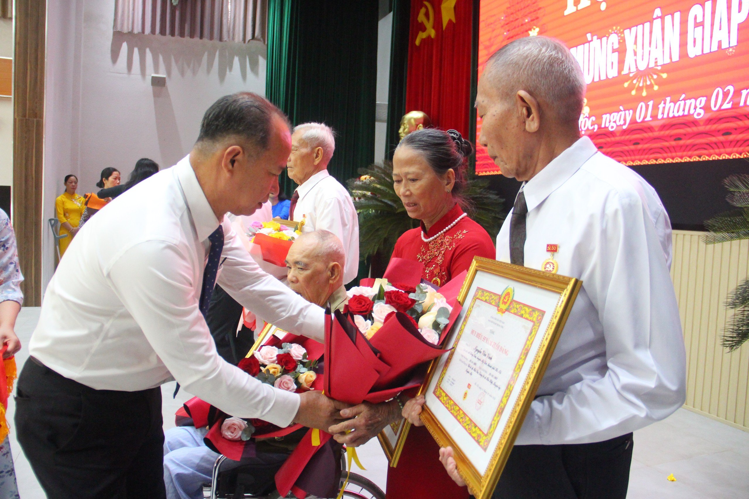Ông Huỳnh Kim Sơn, Phó Bí thư Huyện uỷ Xuyên Mộc tăng hoa, trao Huy hiệu Đảng cho các đảng viên từ 55 đến 60 năm tuổi Đảng.