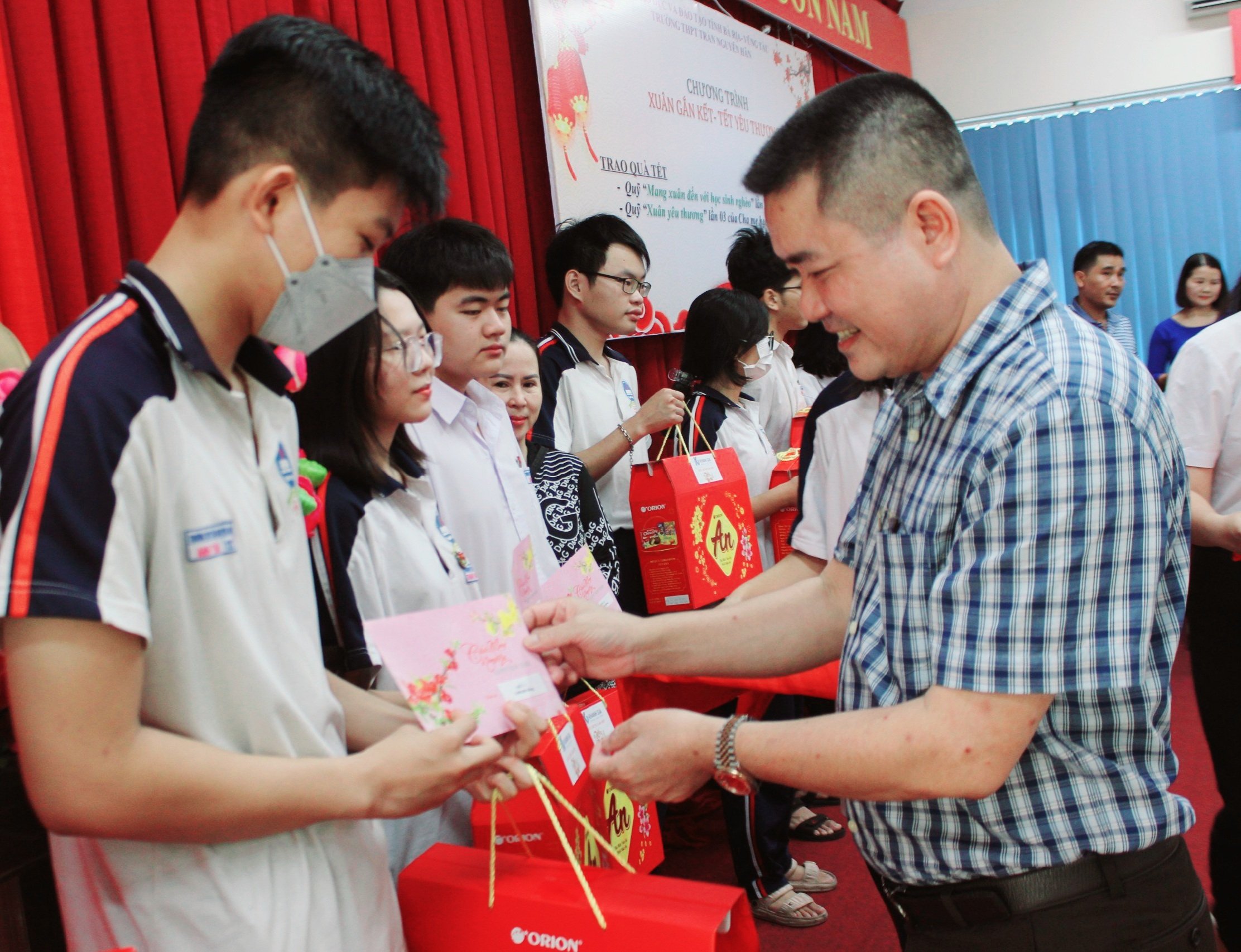 Ông Lương Văn Chí, Trưởng Ban đại diện cha mẹ HS trao quà cho các em HS có hoàn cảnh khó khăn của Trường THPT Trần Nguyên Hãn.