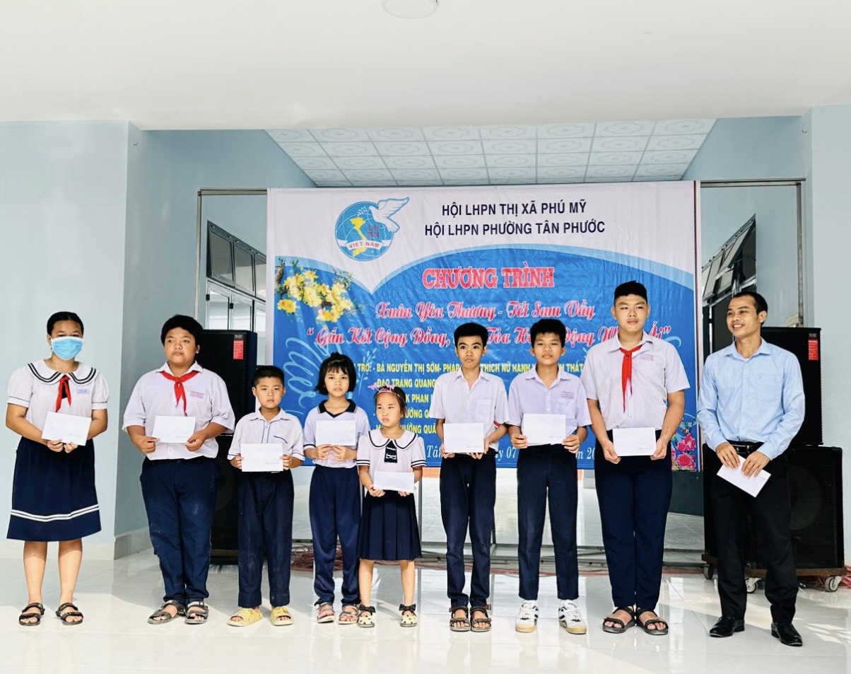 Đại diện nhà tài trợ trao tiền hỗ trợ cho các trẻ mồ côi được nhận đỡ đầu.