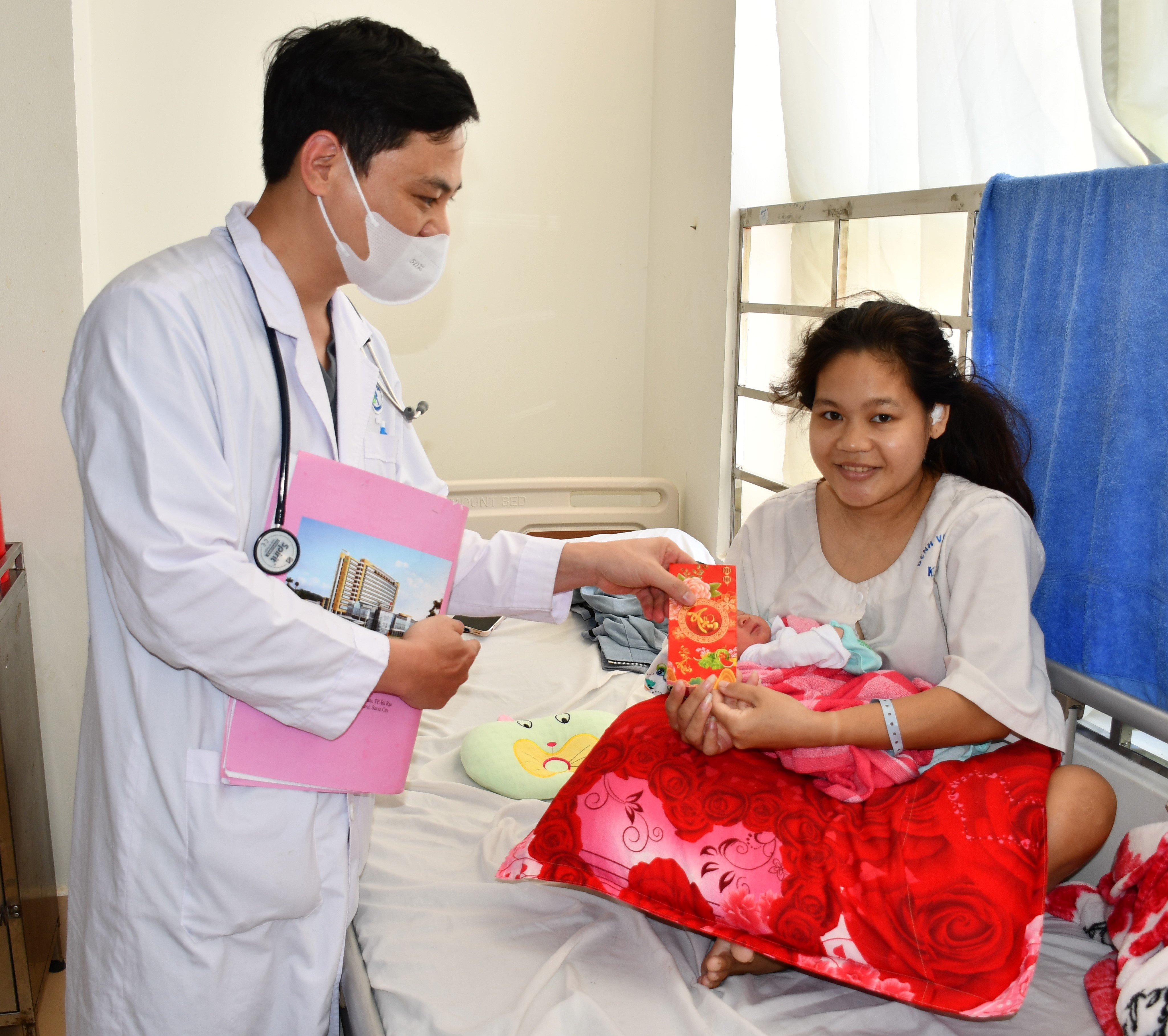 Bác sĩ Hà Văn Viễn (Khoa Phụ sản, Bệnh viện Bà Rịa) lì xì cho mẹ con  sản phụ Lê Thị Phượng.