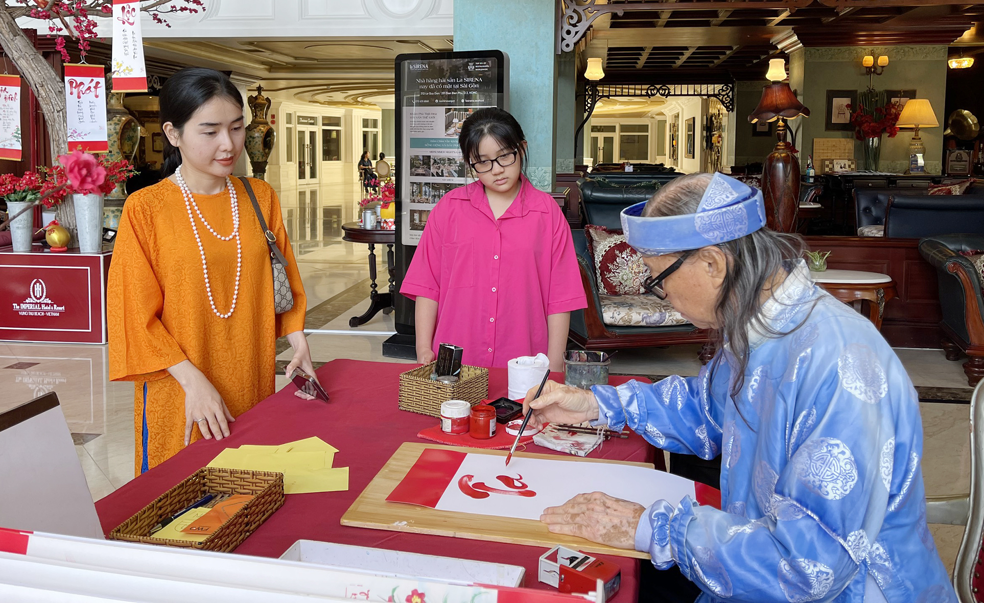 Chị Nguyễn Thị Kim Oanh (Đồng Tháp) xin chữ ông đồ khi nghỉ dưỡng tại The Imperial Hotel.