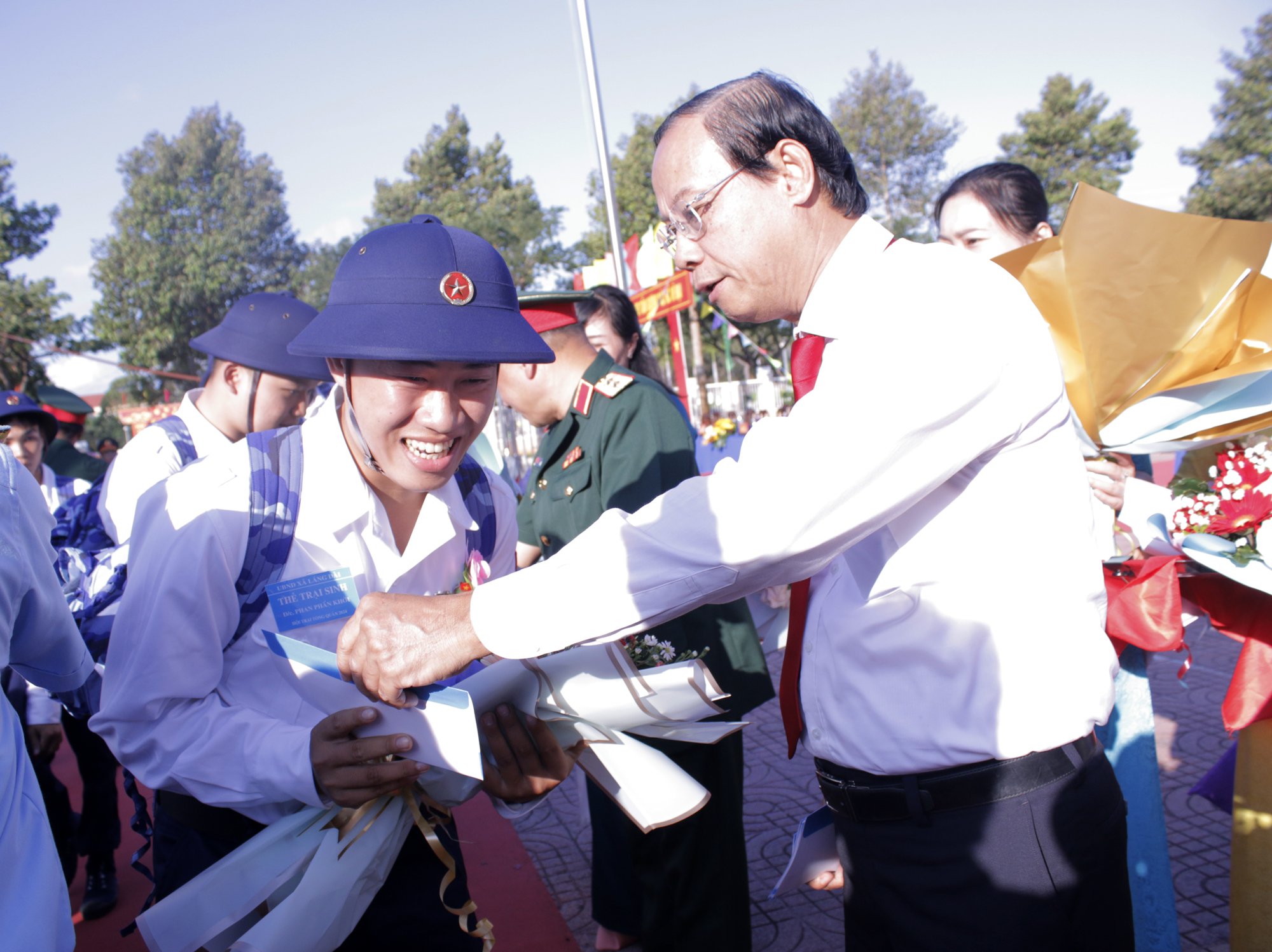 Ông Nguyễn Văn Thọ, Chủ tịch UBND tỉnh, Chủ tịch Hội đồng NVQS tỉnh tặng hoa và quà cho các tân binh huyện Đất Đỏ tại lễ giao quân sáng 27/2. Ảnh: VÂN ANH