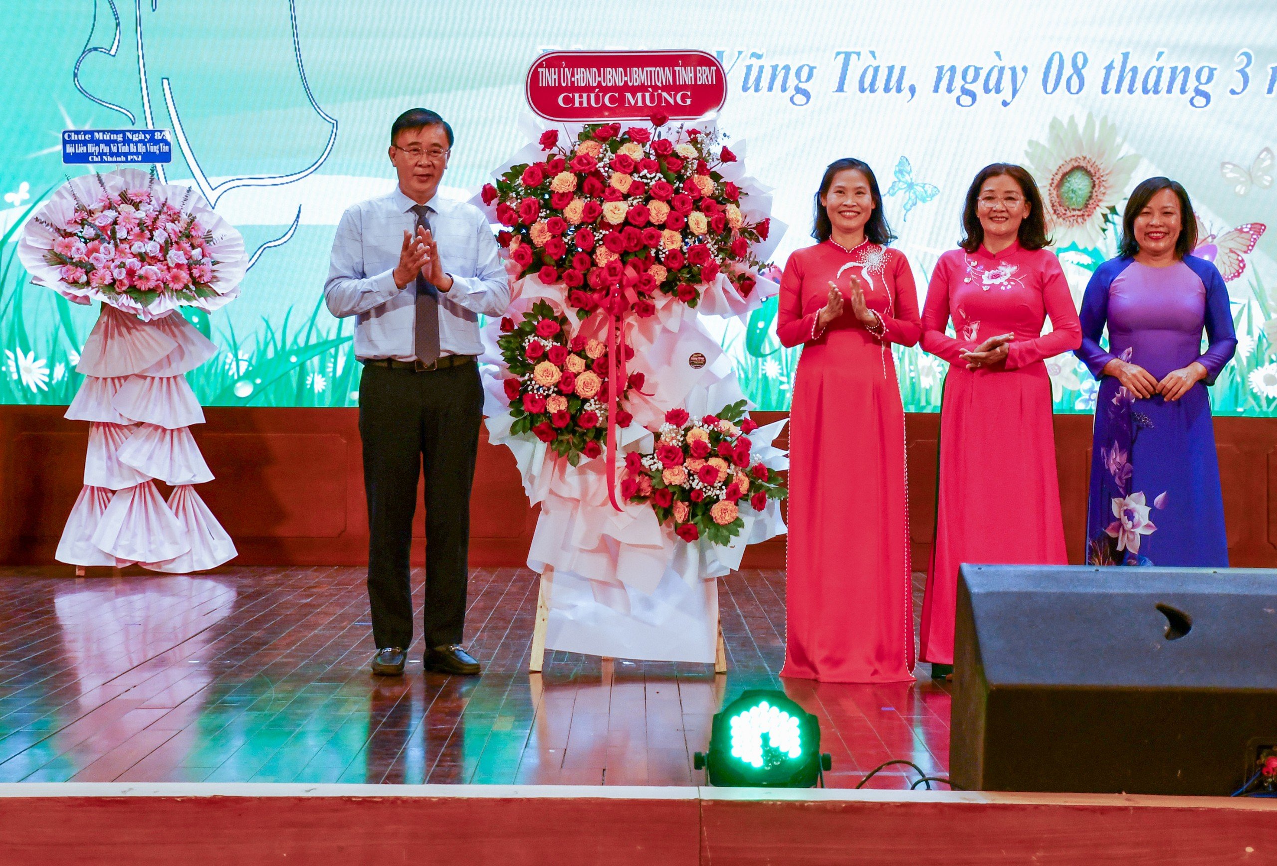 Ông Huỳnh Văn Danh, Trưởng Ban Dân vận Tỉnh ủy tặng lẵng hoa của Tỉnh ủy, HĐND, UBND, UBMTTQ Việt Nam tỉnh đến các đại biểu nữ.