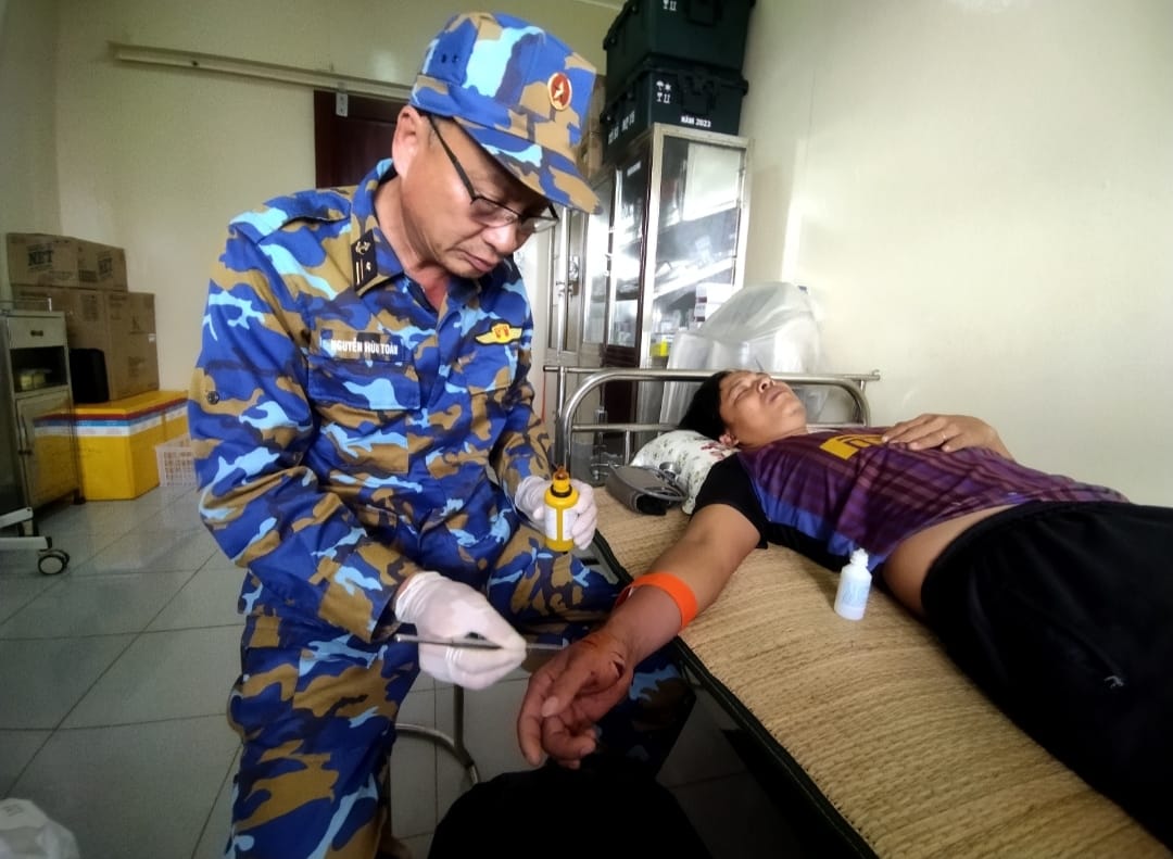 Ngư dân Huỳnh Văn Phát được cán bộ y tế nhà giàn DK1/7 chăm sóc vết thương ở tay do cá cắn.