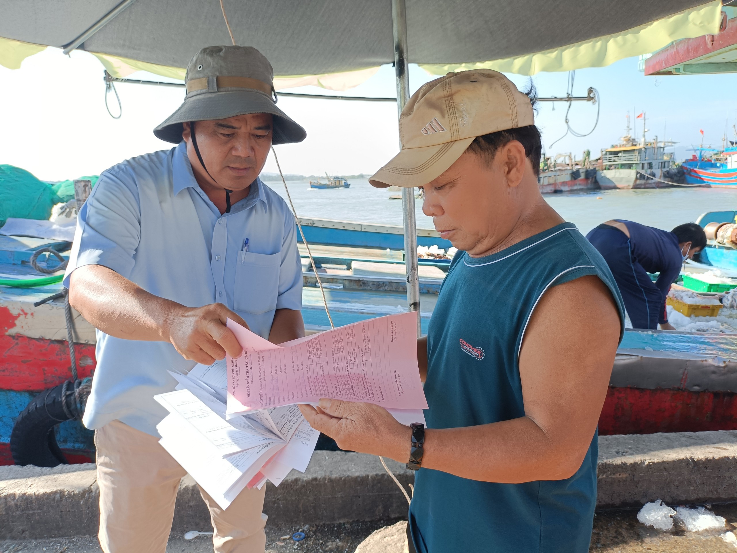 Nhân viên cảng cá Tân Phước (xã Phước Tỉnh, huyện Long Điền) kiểm tra giấy tờ, sản lượng và thu nhật ký khai thác tàu cá vừa cập bến theo quy định chống khai thác IUU