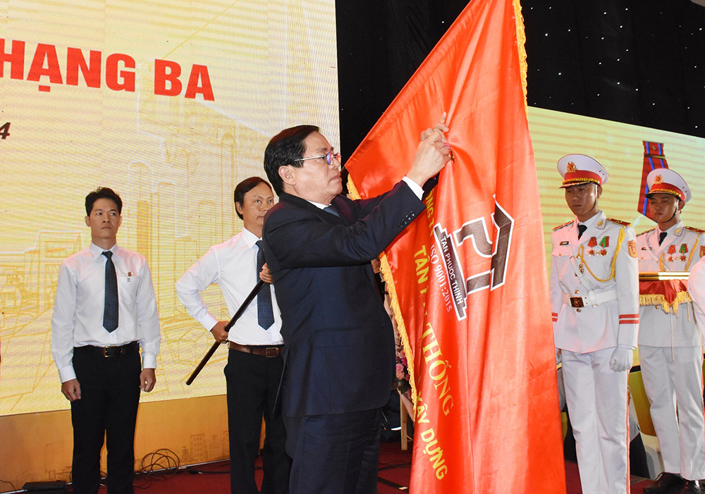 Ông Phạm Viết Thanh, Ủy viên Trung ương Đảng, Bí thư Tỉnh ủy, Chủ tịch HĐND tỉnh gắn Huân chương Lao động hạng Ba lên cờ truyền thống của Công ty CP Đầu tư và Xây dựng Tân Phước Thịnh.