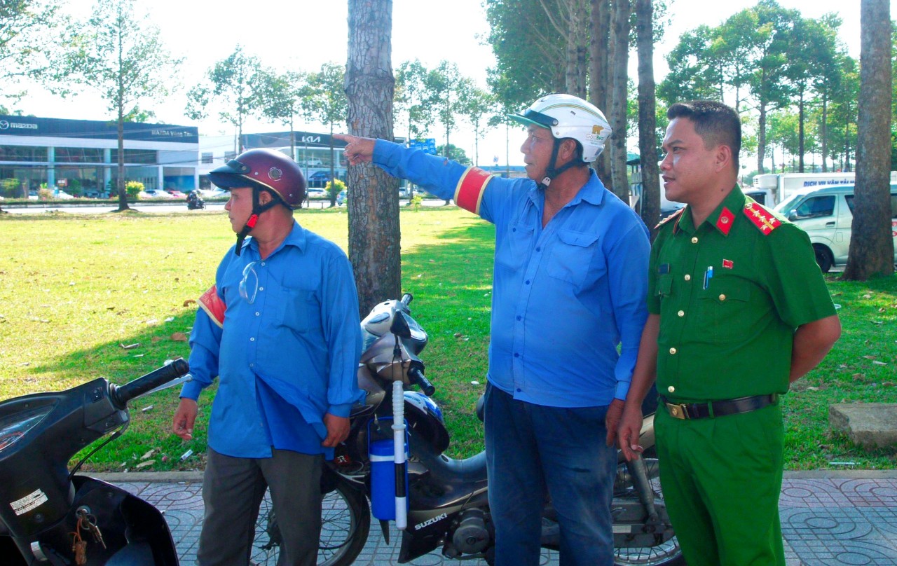 Cán bộ Công an phường Phước Trung trao đổi thông tin về an ninh trật tự với tổ xe ôm tự quản.