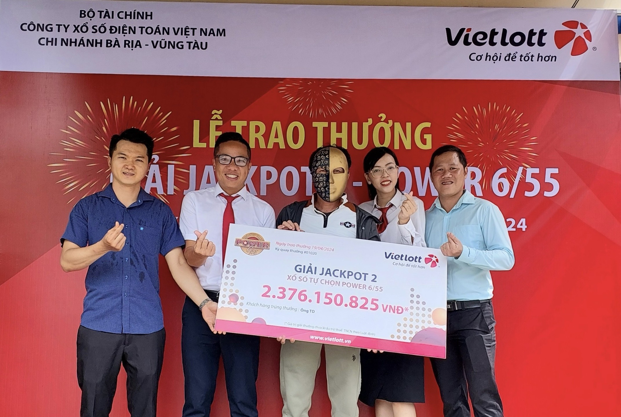 Đại diện Vietlott và các đơn vị liên quan chụp hình lưu niệm với khách hàng trúng thưởng.