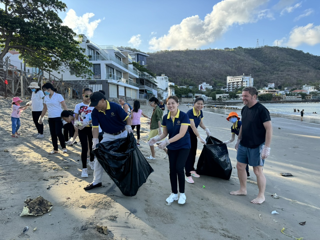 Hơn 20 người là khách lưu trú, cán bộ công nhân viên khu căn hộ khách sạn Ocean Sunrise thu gom rác trên bãi biển.