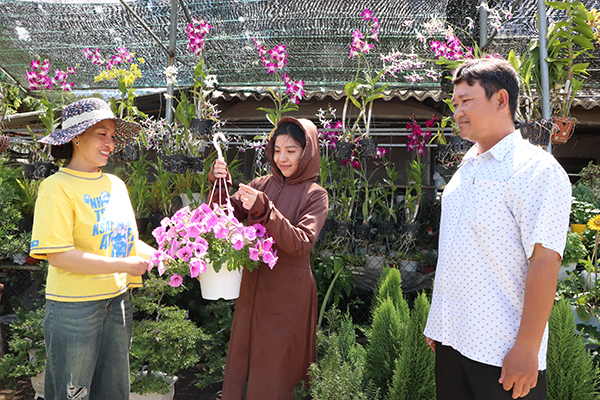 Chị Nguyễn Thị Xuân (bên trái), Tổ hợp tác sản xuất, kinh doanh cây kiểng (KP.Hải An, TT.Long Hải) giới thiệu với khách hàng các loại hoa kiểng.