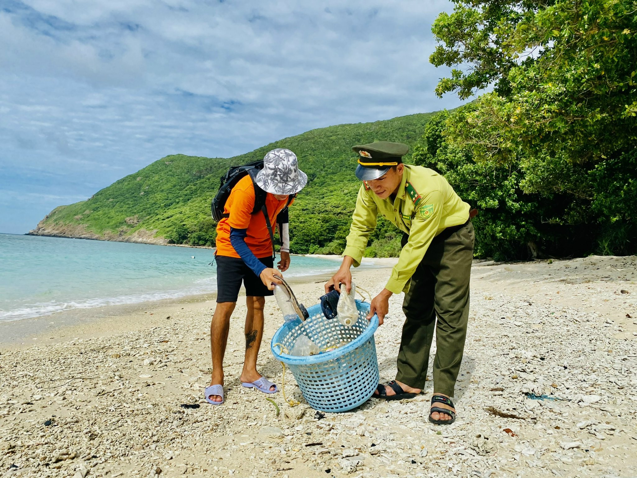 Lực lượng kiểm lâm và khách du lịch thu gom rác trên bãi biển Côn Đảo.
