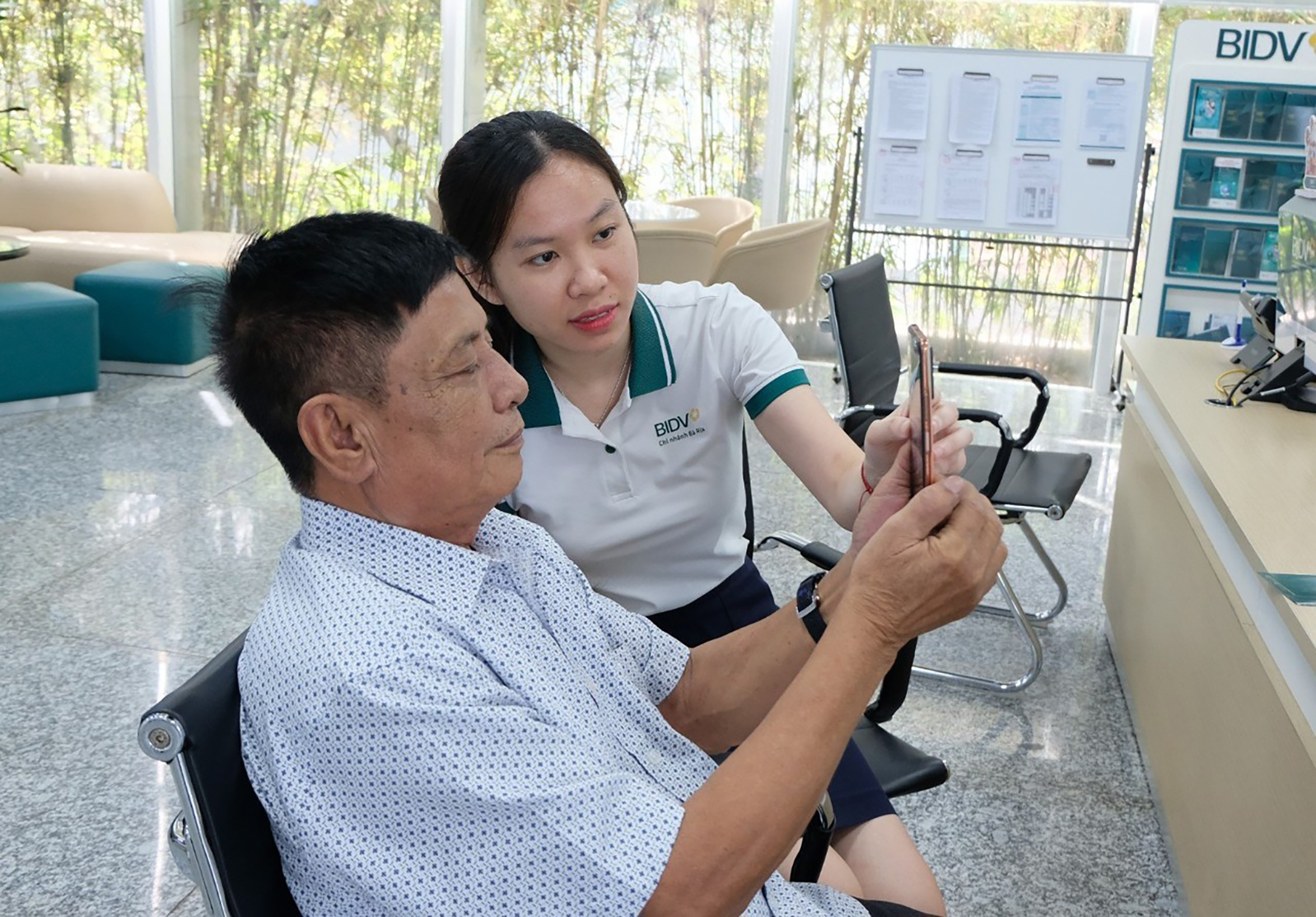 Nhân viên BIDV Bà Rịa hướng dẫn khách hàng cài đặt ứng dụng để thực hiện các giao dịch của ngân hàng.