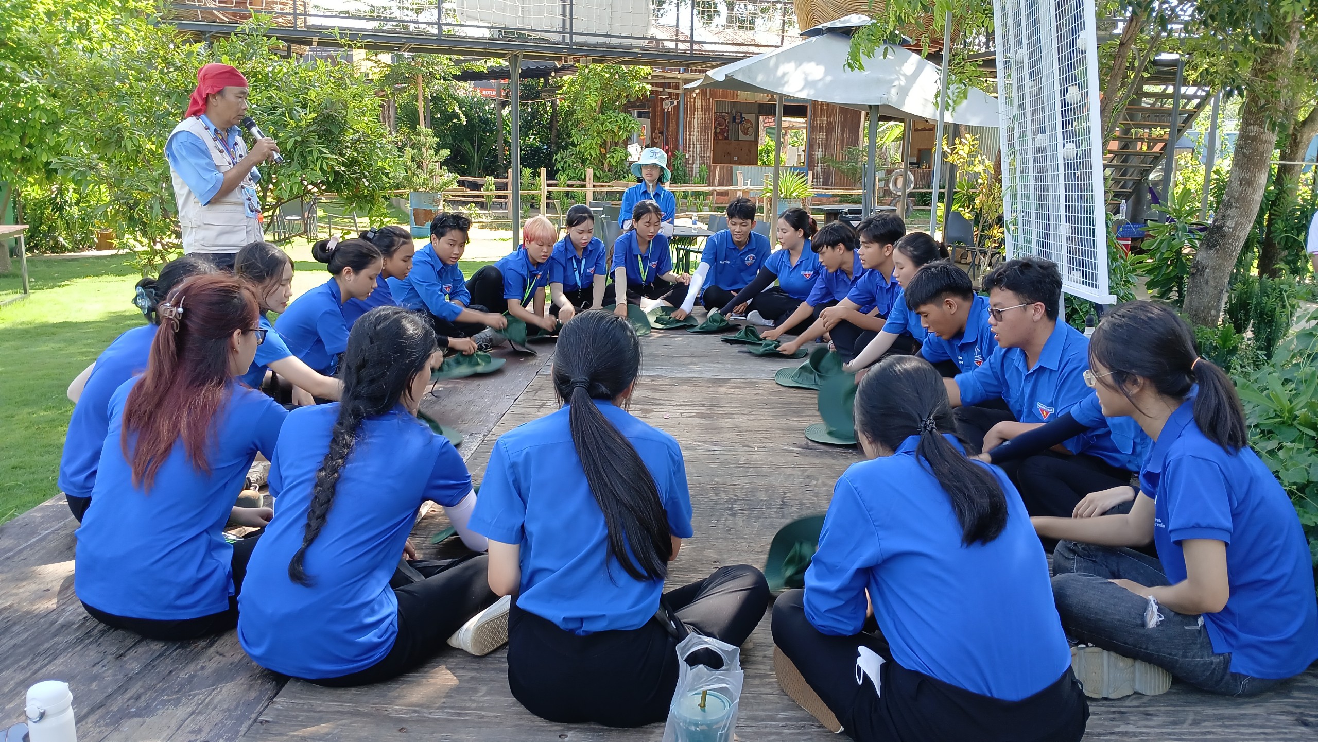 Trại sinh tham gia thử thách trò chơi nhập trại hát có động tác với mũ.
