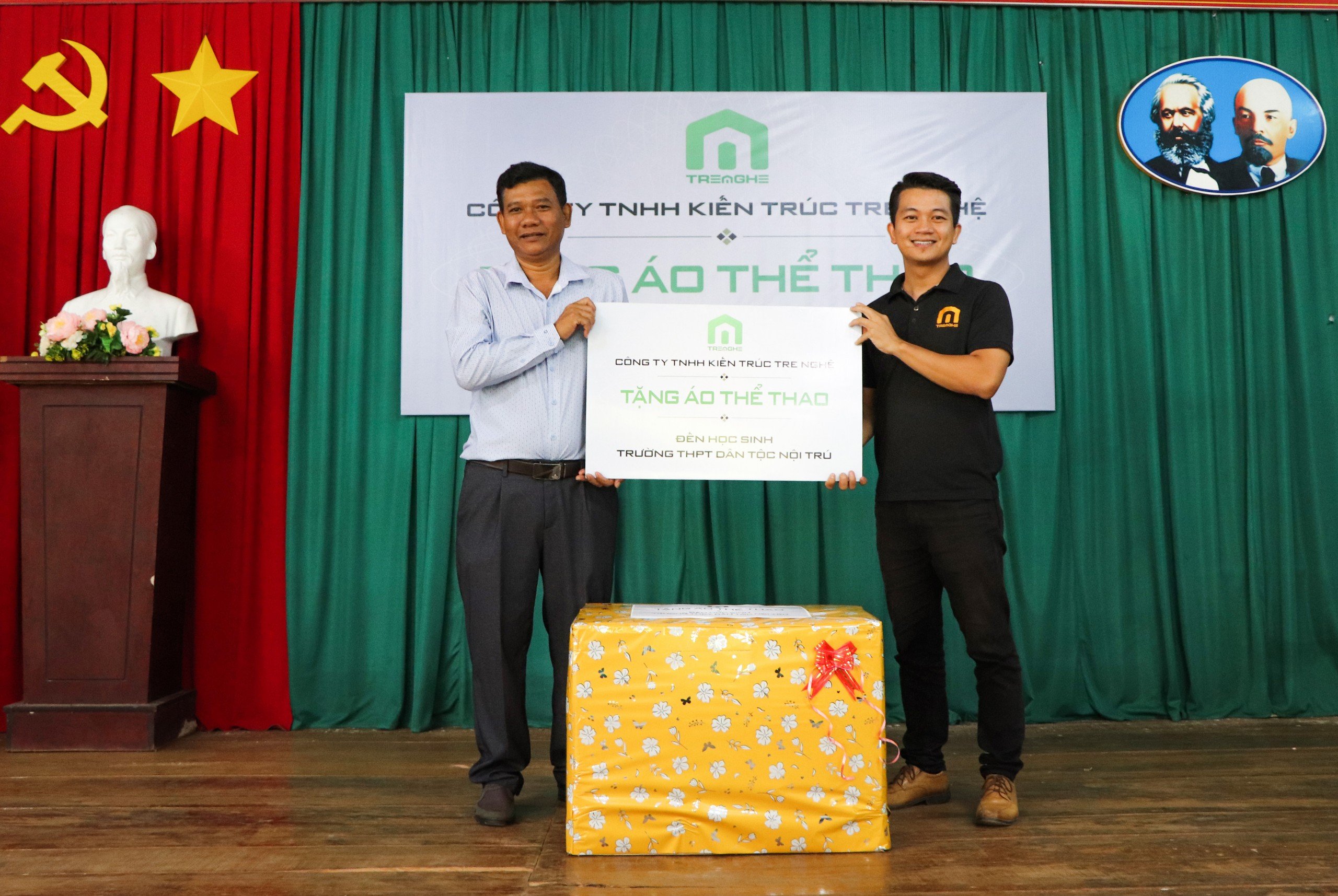 Ông Đào Văn Phước (trái), Hiệu trưởng Trường Phổ thông Dân tộc nội trú nhận áo thể thao do Công ty TNHH Kiến trúc Tre Nghệ trao tặng.